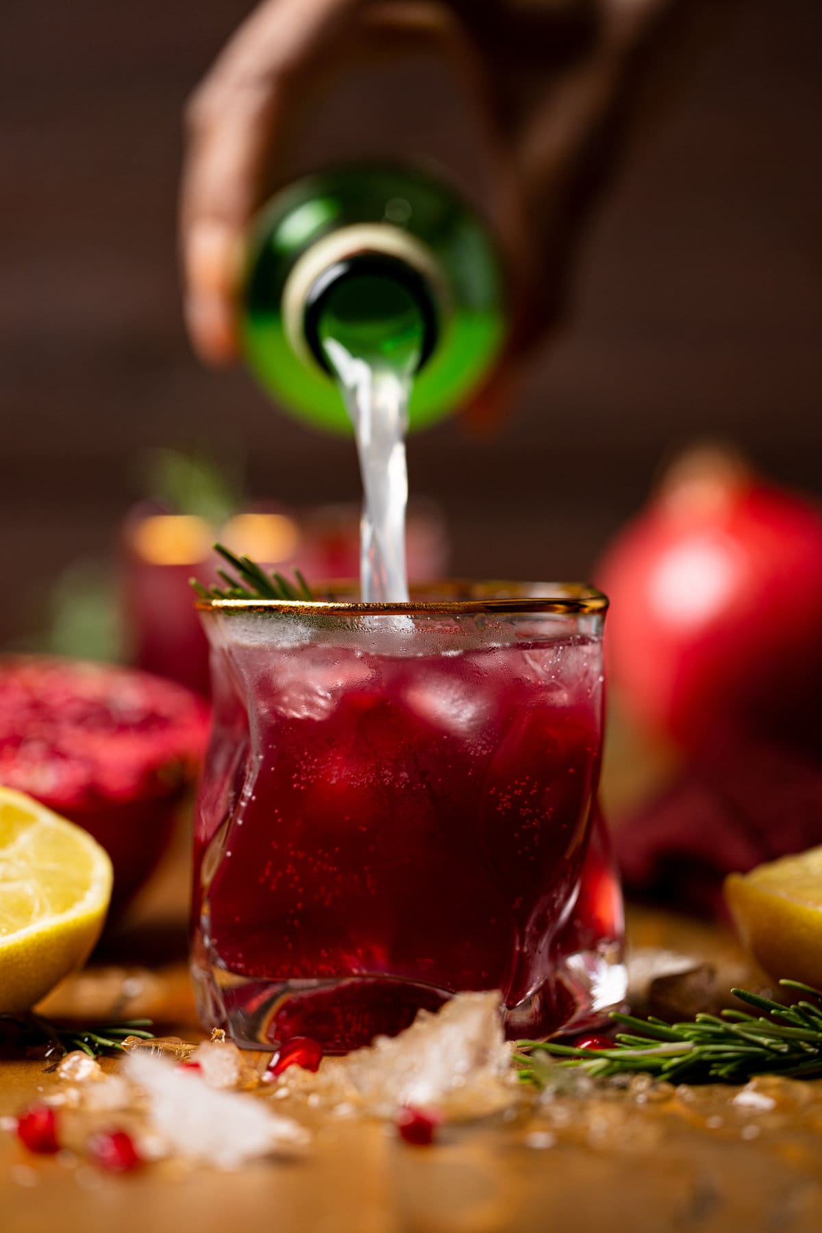 Ginger beer pouring into a Holiday Pomegranate Ginger Mocktail