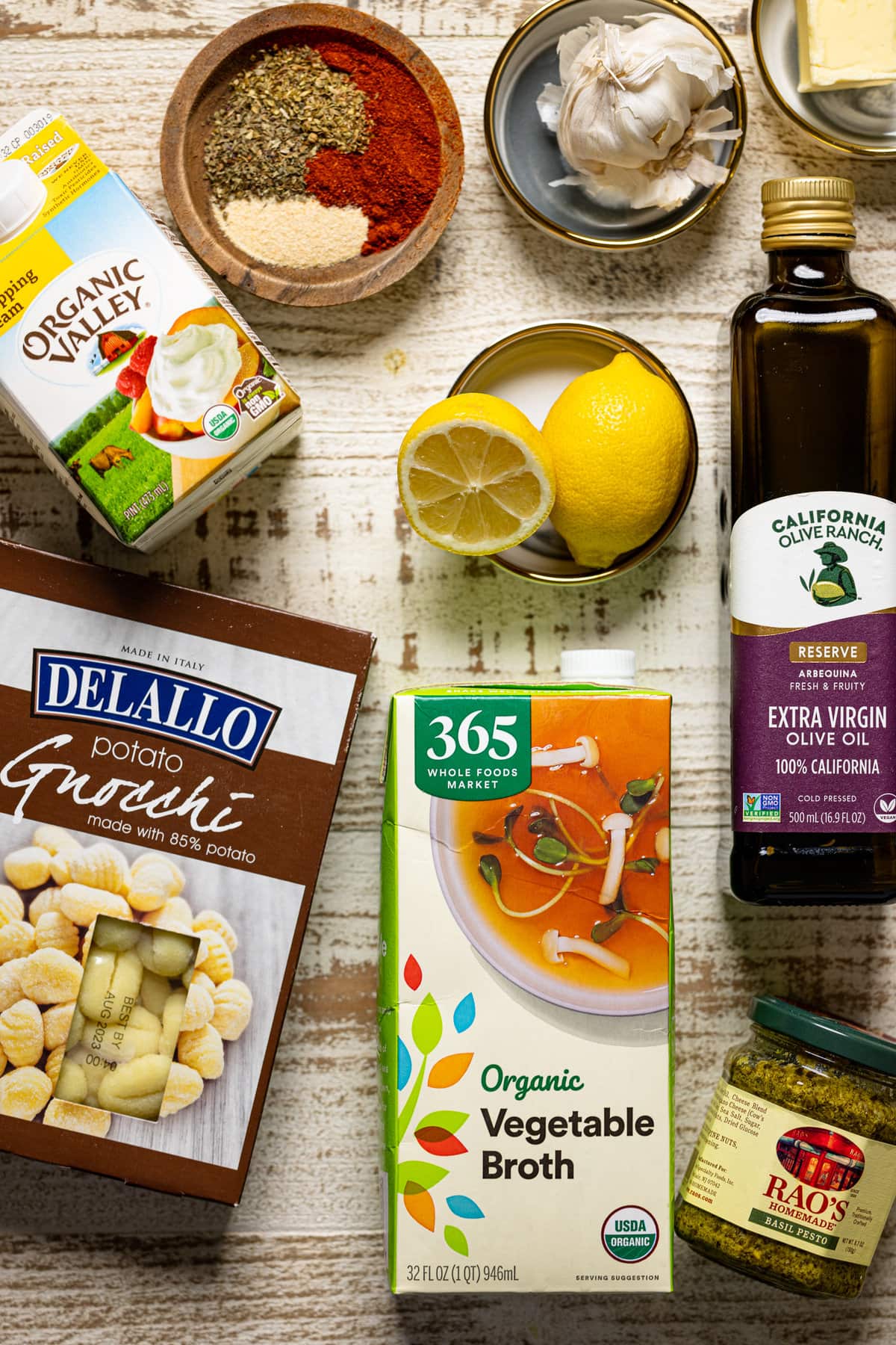 Ingredients for Creamy Lemon Pesto Gnocchi with Broccoli including vegetable broth, lemons, heavy whipping cream, and garlic