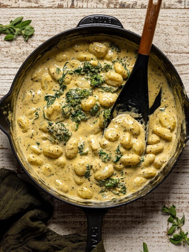 Overhead shot of Creamy Lemon Pesto Gnocchi with Broccoli being stirred with a spoon