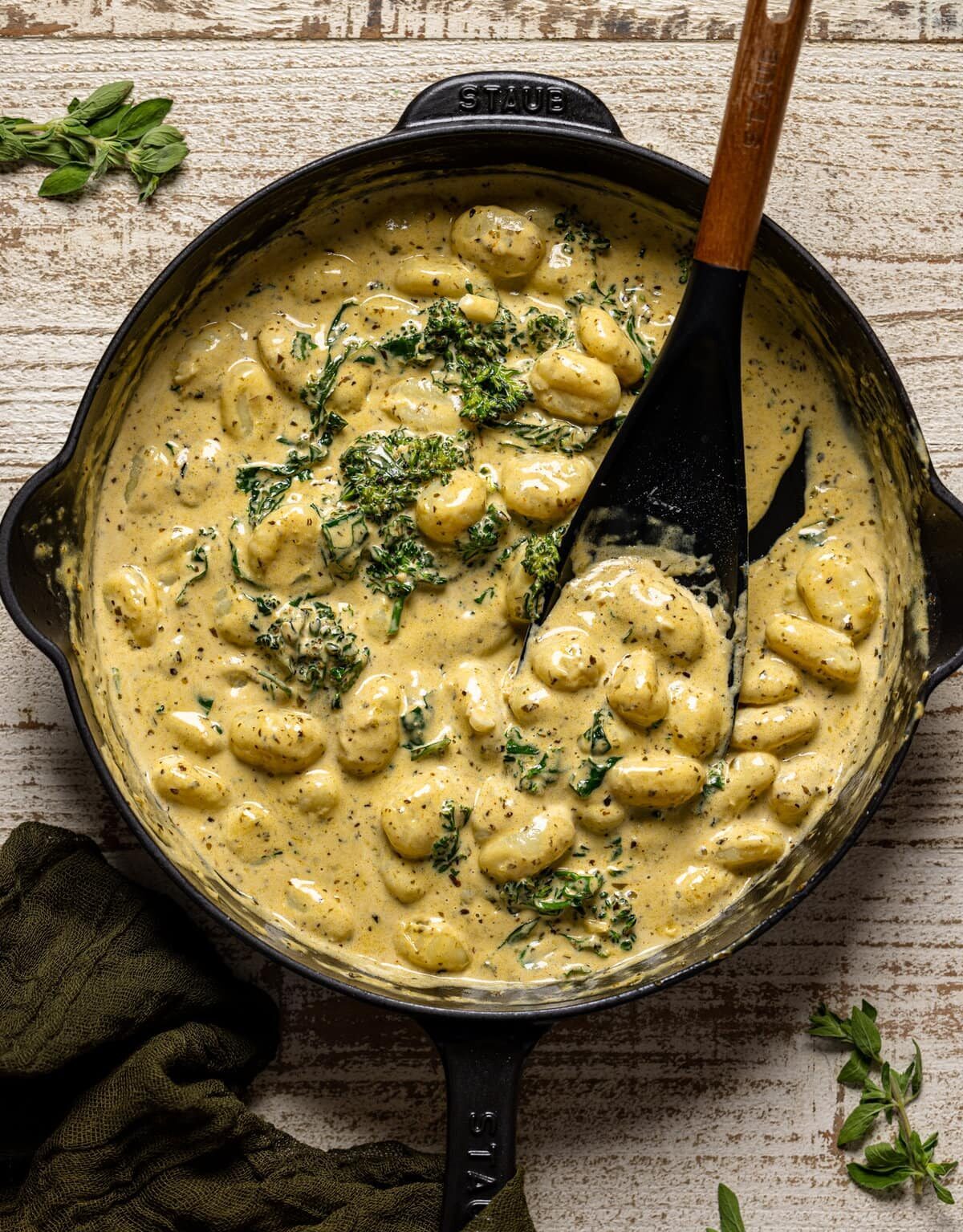 Overhead shot of Creamy Lemon Pesto Gnocchi with Broccoli being stirred with a spoon