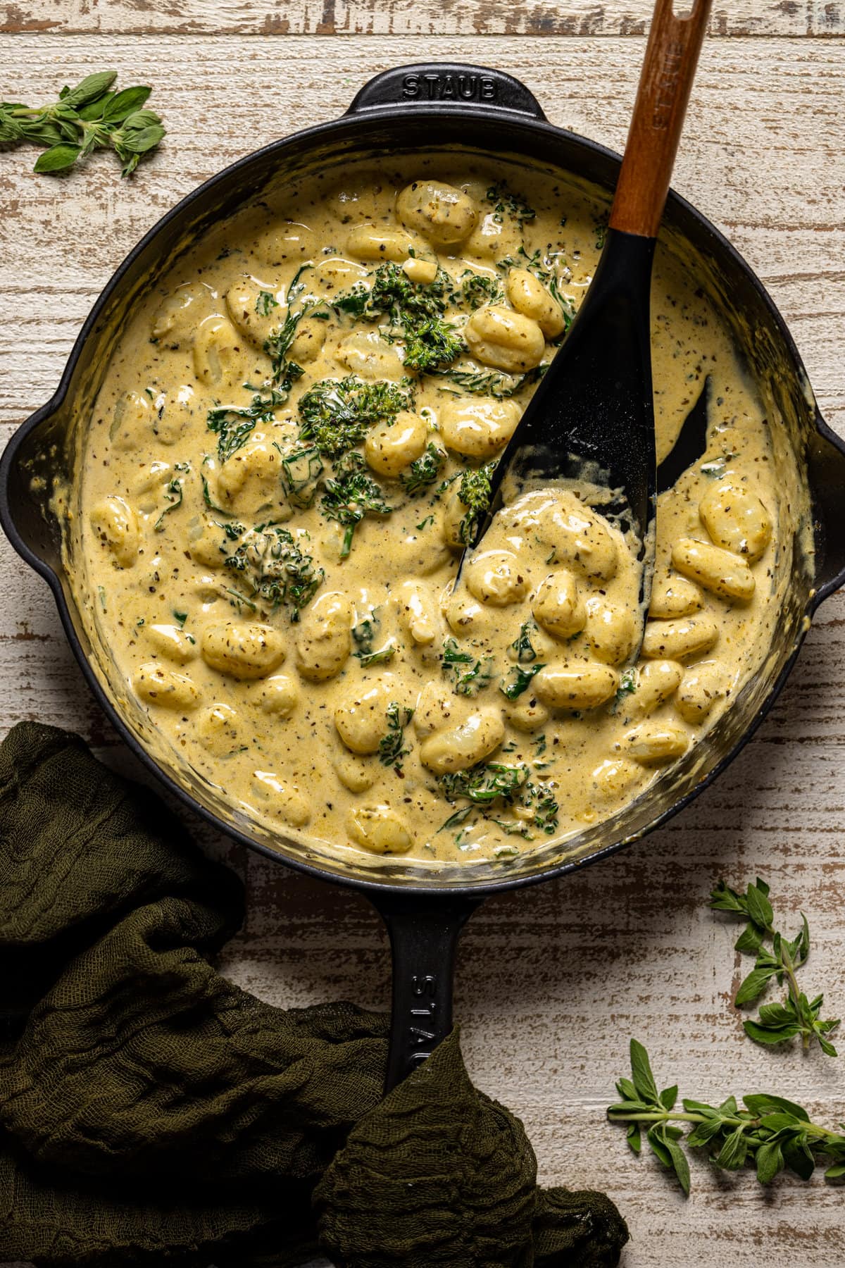 Creamy Lemon Pesto Gnocchi with Broccoli being stirred with a spoon