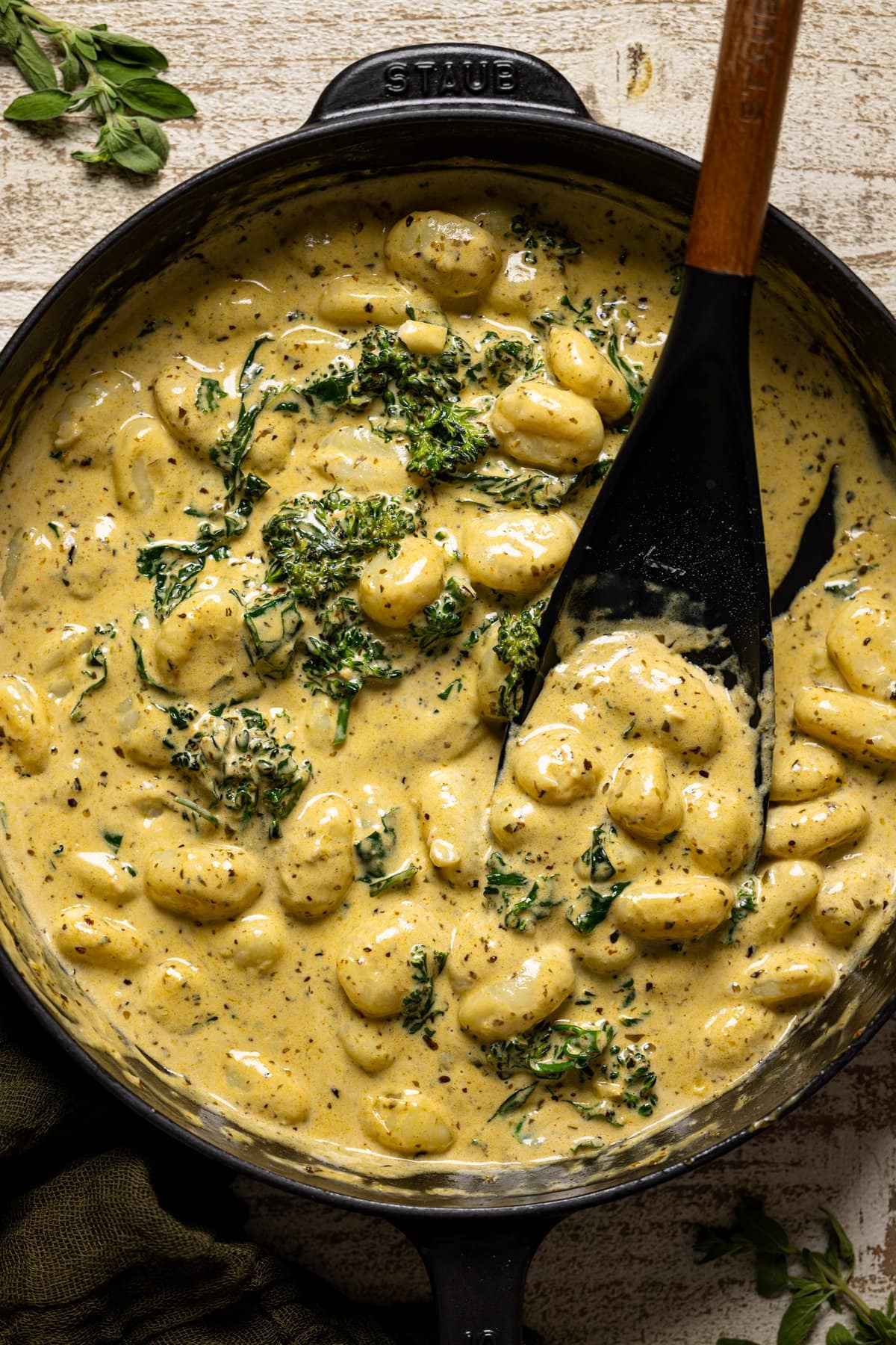 Closeup of Creamy Lemon Pesto Gnocchi with Broccoli being stirred with a spoon. Vegan pasta option.