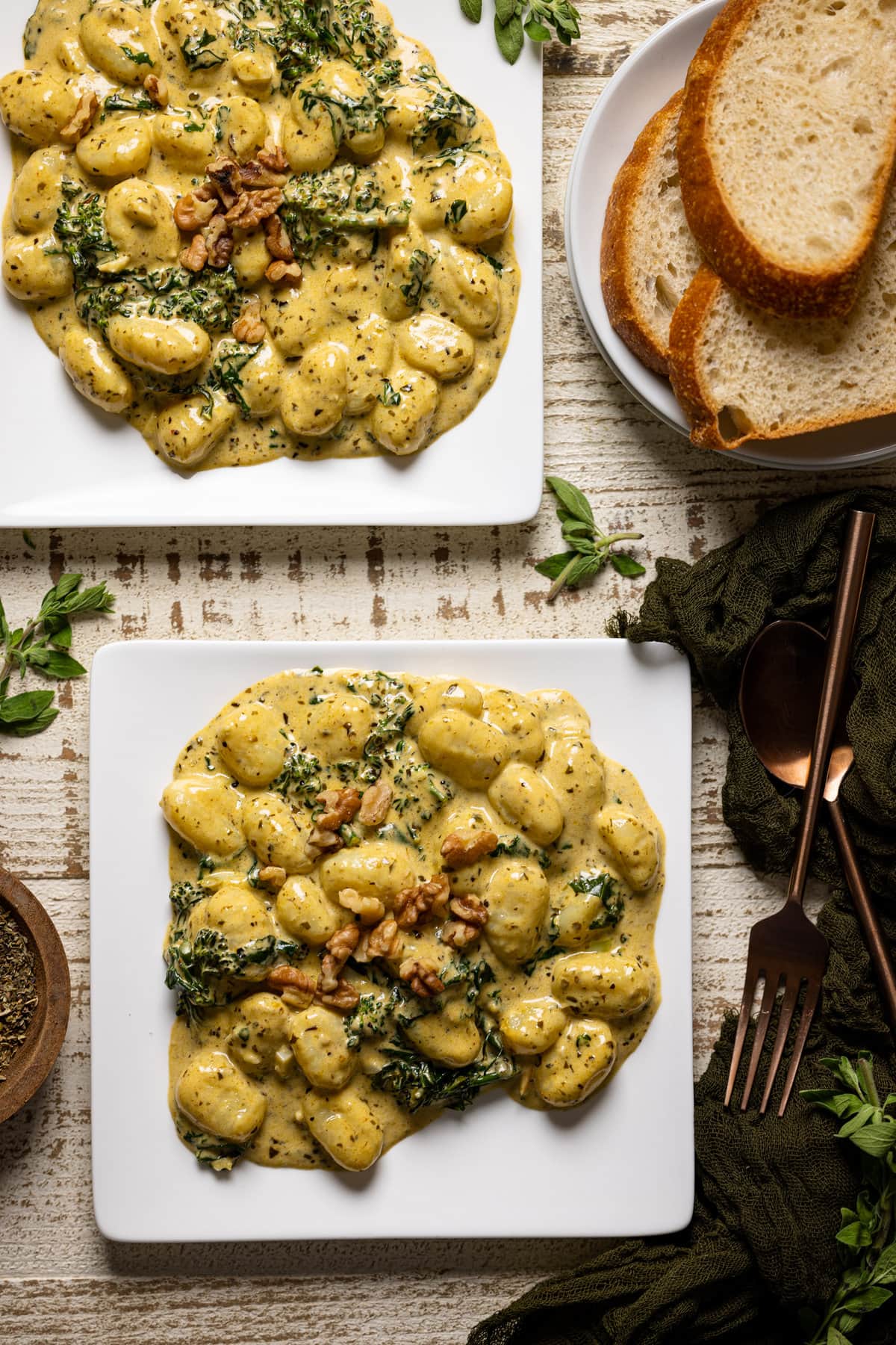 Overhead shot of two plates of Creamy Lemon Pesto Gnocchi with Broccoli