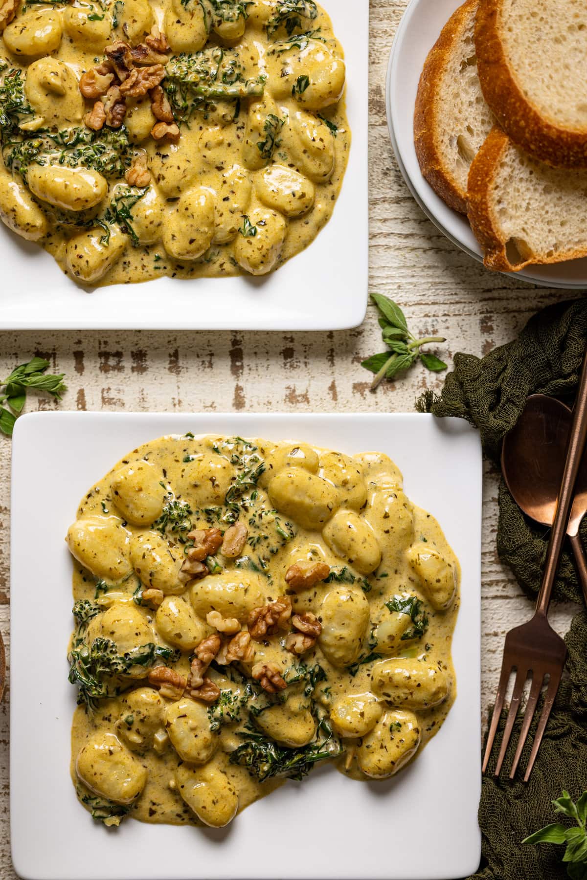 Overhead shot of two plates of Creamy Lemon Pesto Gnocchi with Broccoli