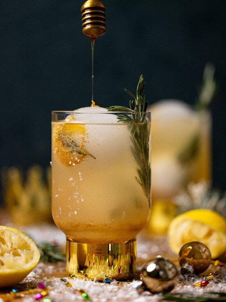 Honey drizzling into a glass of Hot Honey Lemon Mocktail