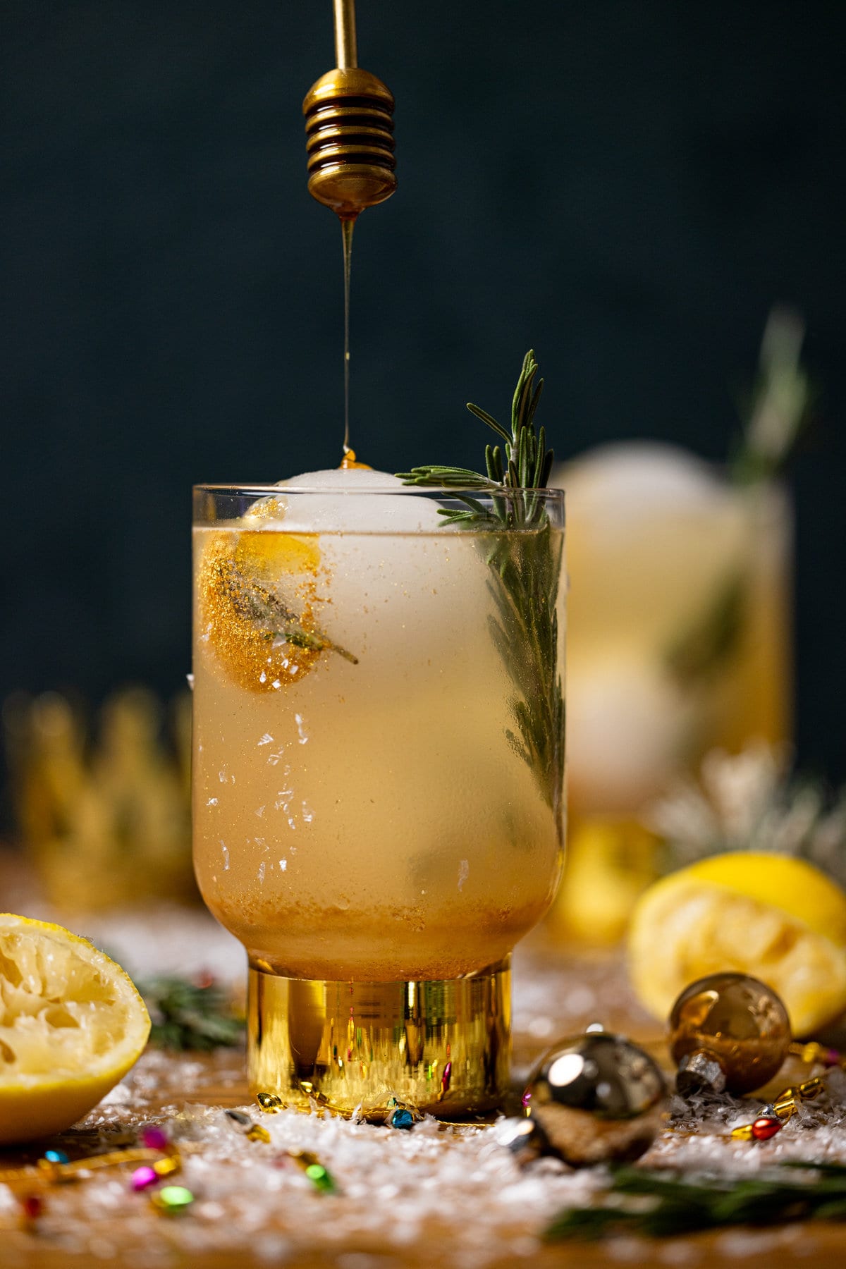 Honey drizzling into a glass of Hot Honey Lemon Mocktail