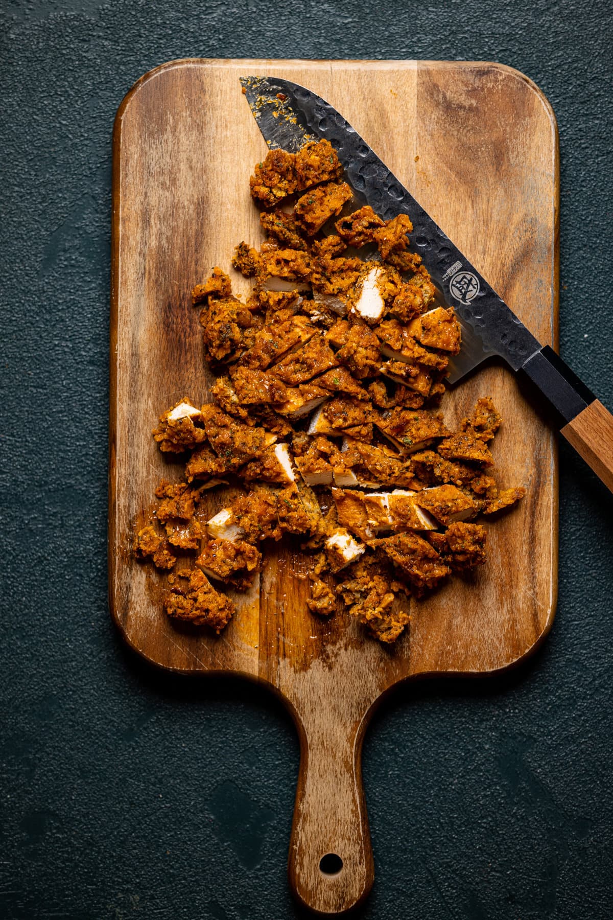 Chopped chicken on a cutting board with a knife