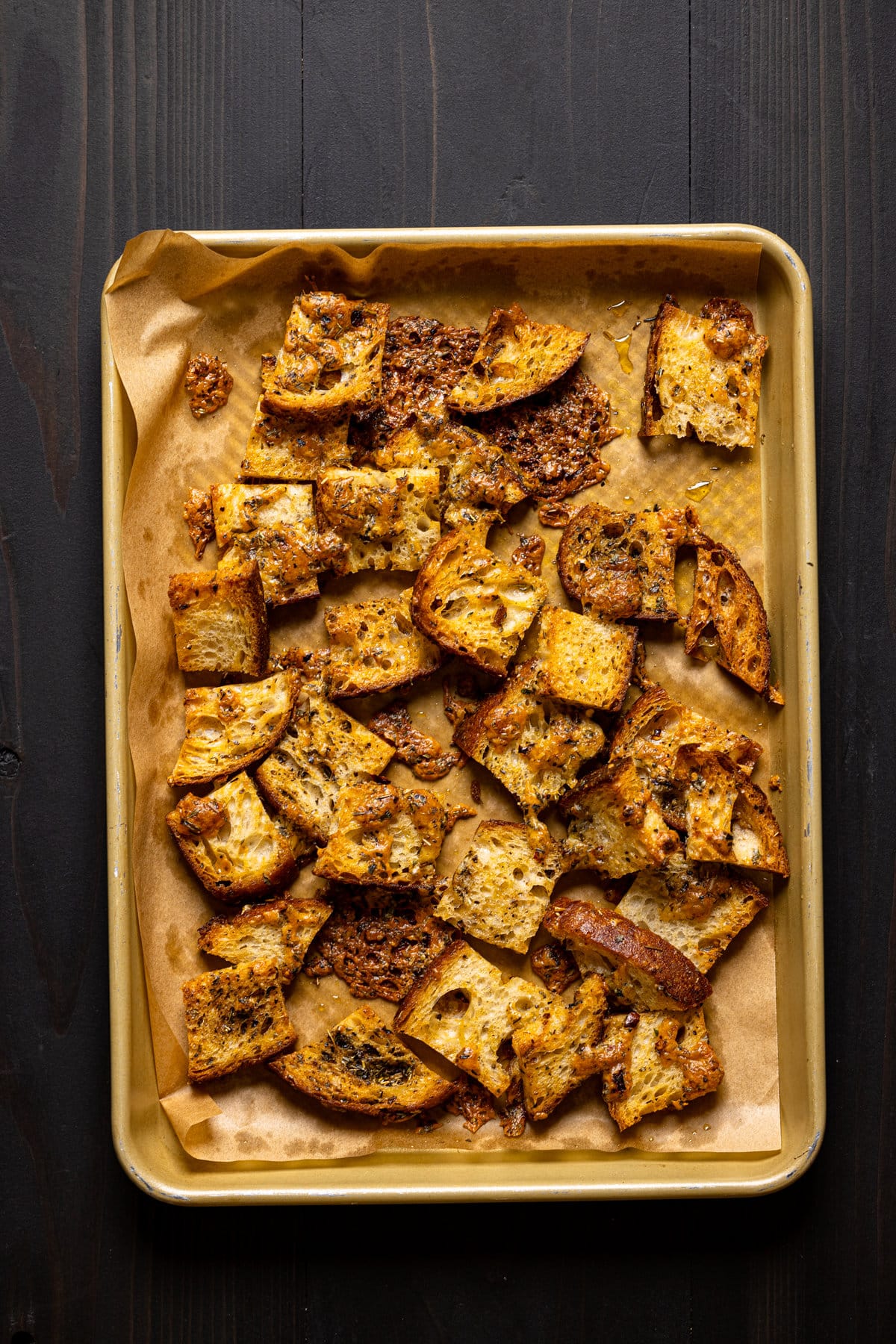 Seasoned bread pieces on a baking sheet