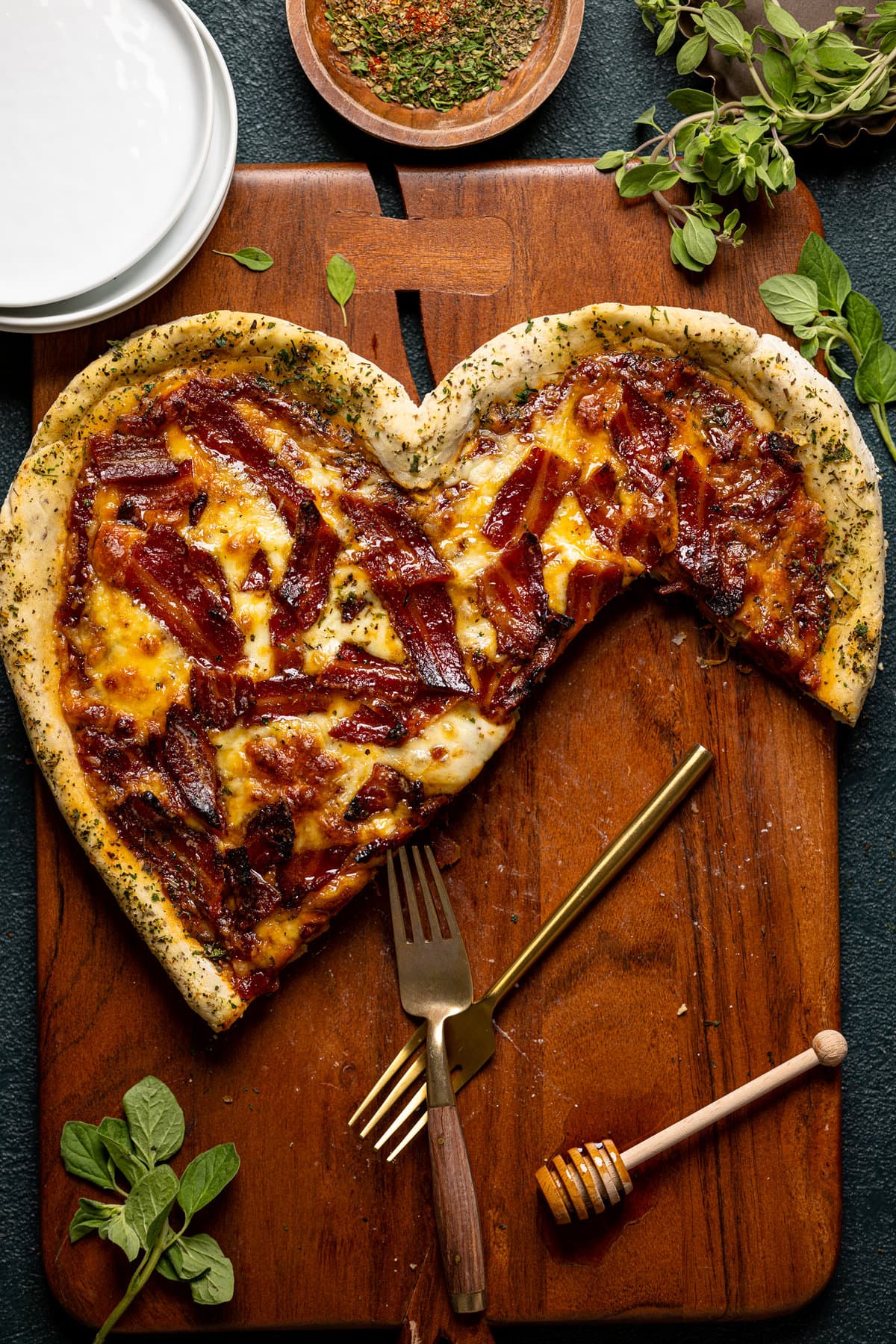 Heart-shaped Gluten-Free Hot Honey Bacon Pizza missing several pieces