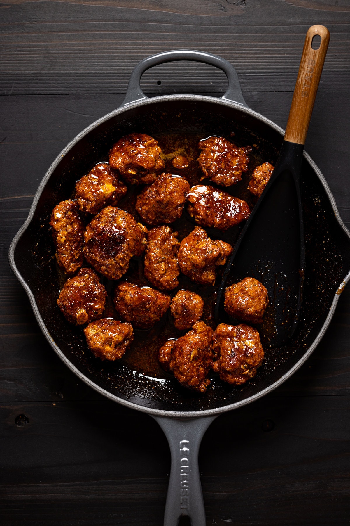Cauliflower bites being tossed in a pan with sauce