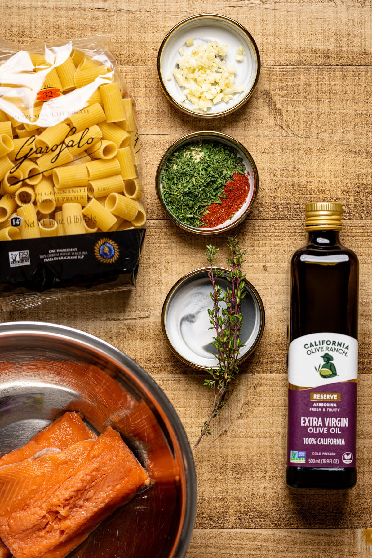 Ingredients for Creamy Salmon Alfredo Pasta including olive oil, pasta, salmon, and spices