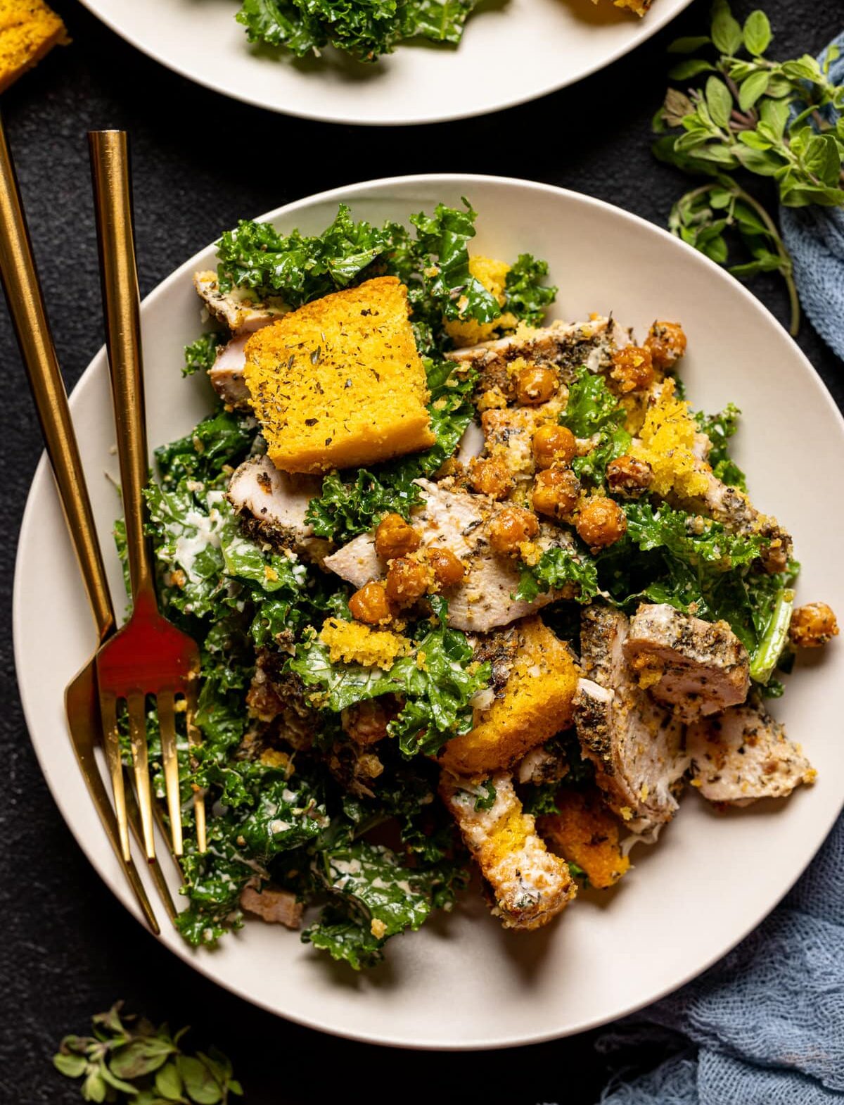 Forks and plate of Chicken Caesar Salad with Cornbread Croutons