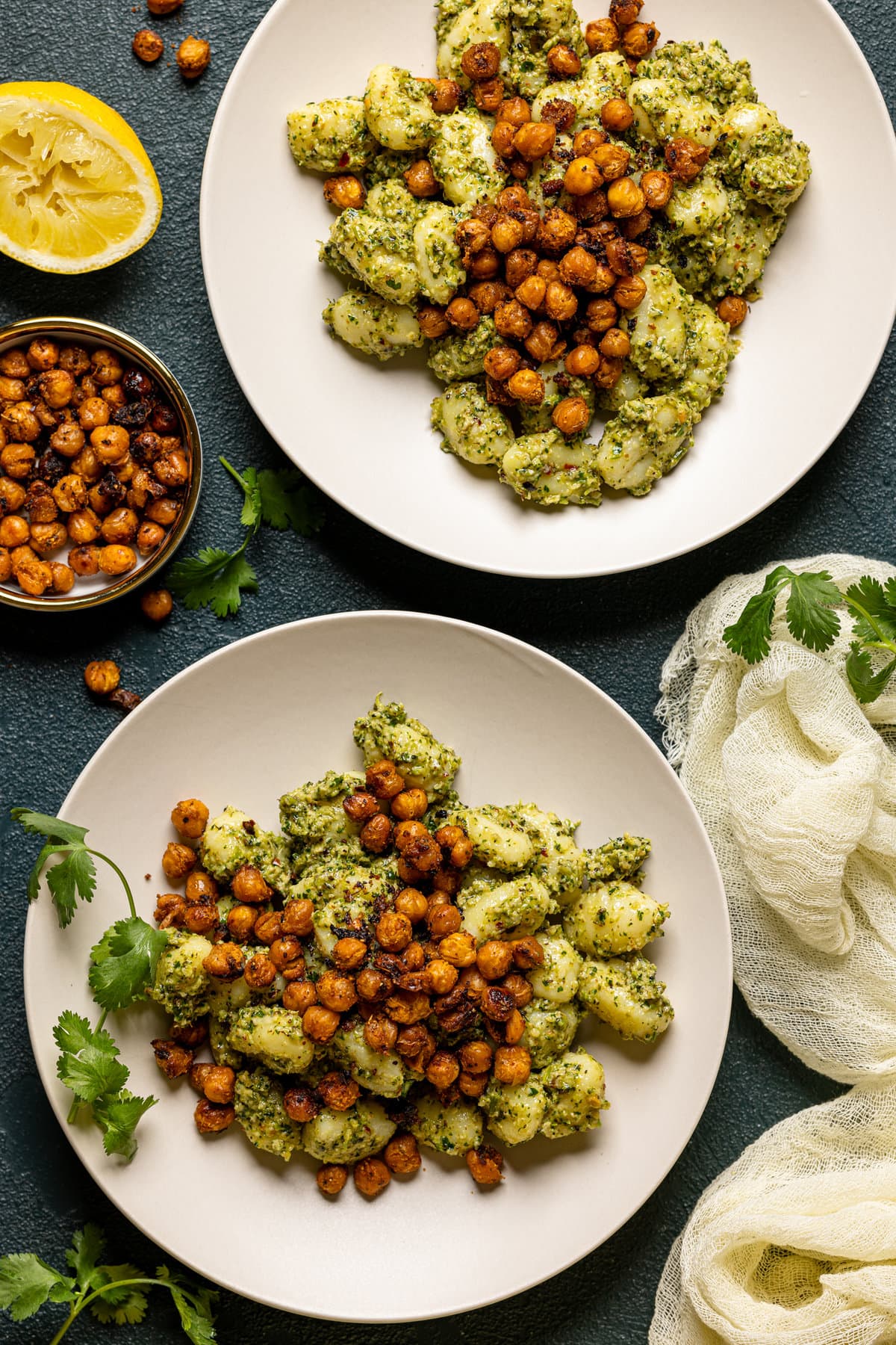 Two plates of broccoli pesto gnocchi with chickpeas