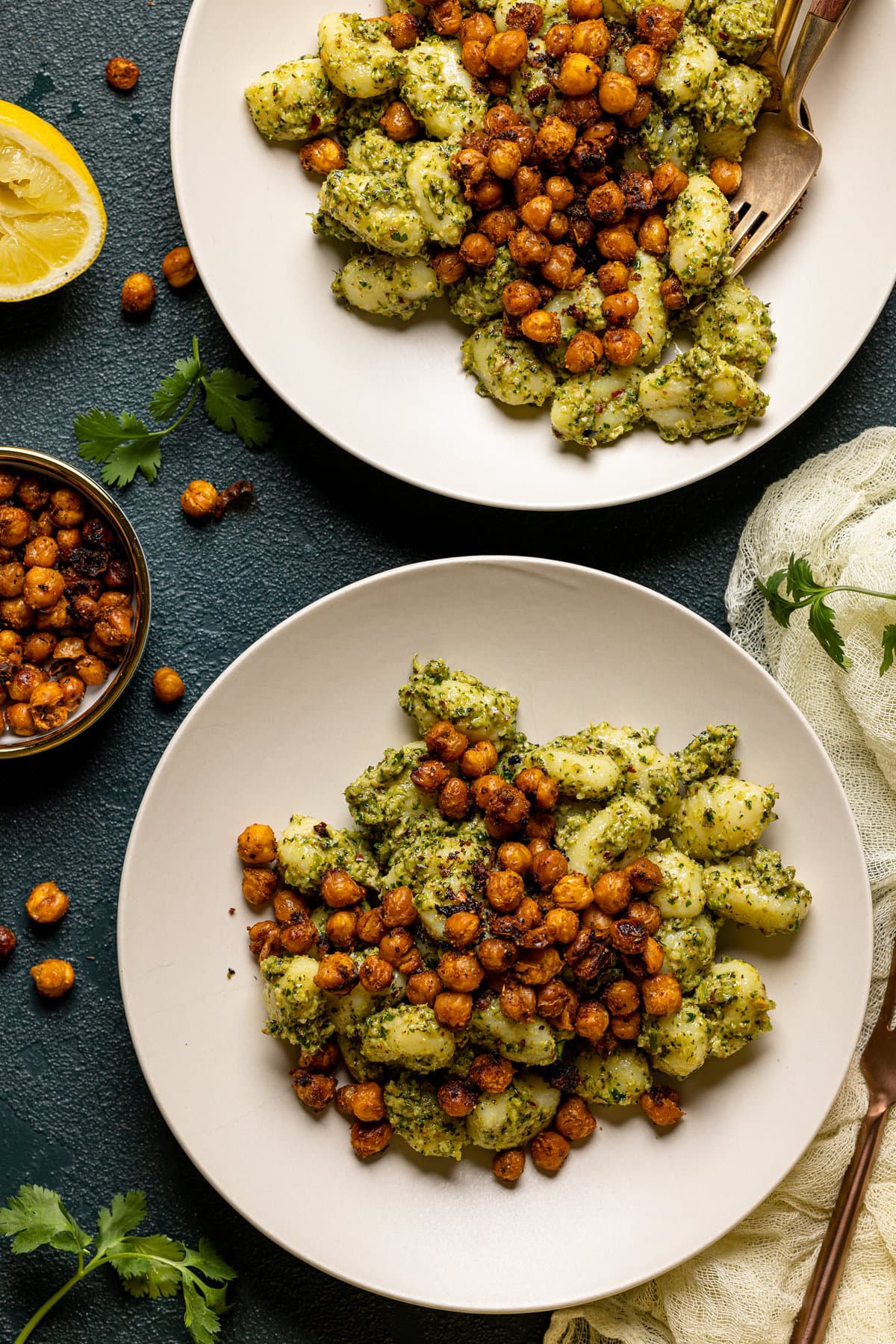 Two plates of broccoli pesto gnocchi with chickpeas