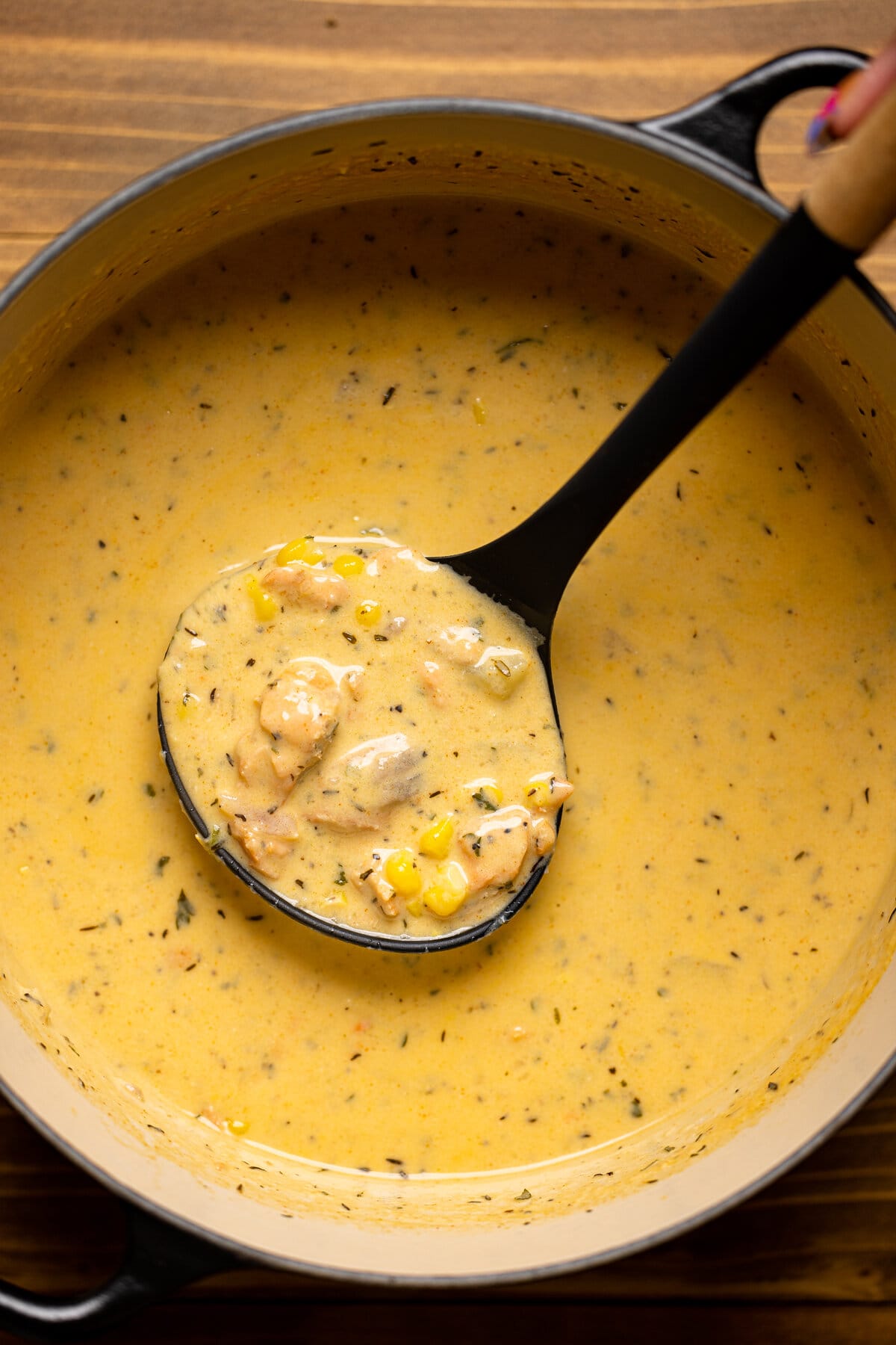 Creamy Blackened Salmon Chowder being scooped with a ladle