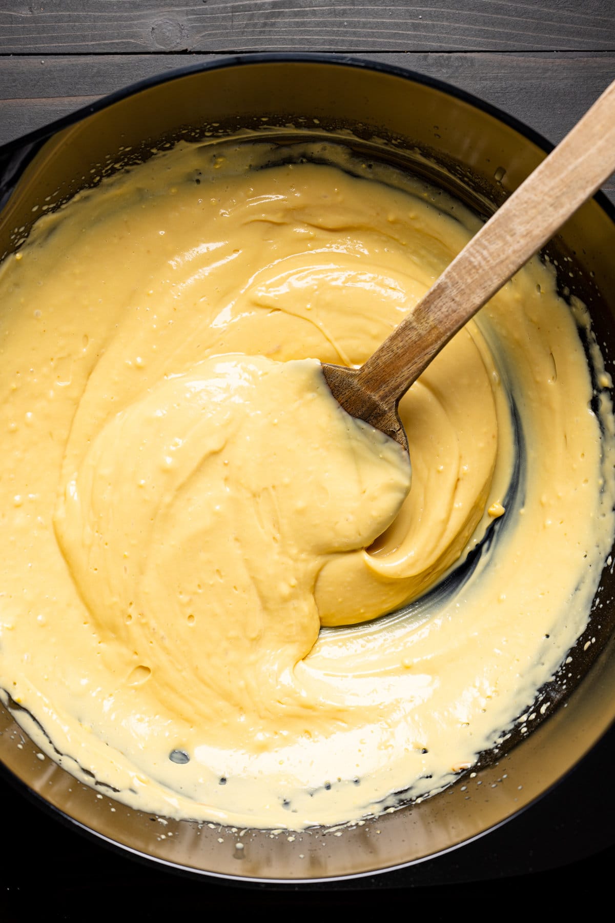 Pudding being mixed with a wooden spoon