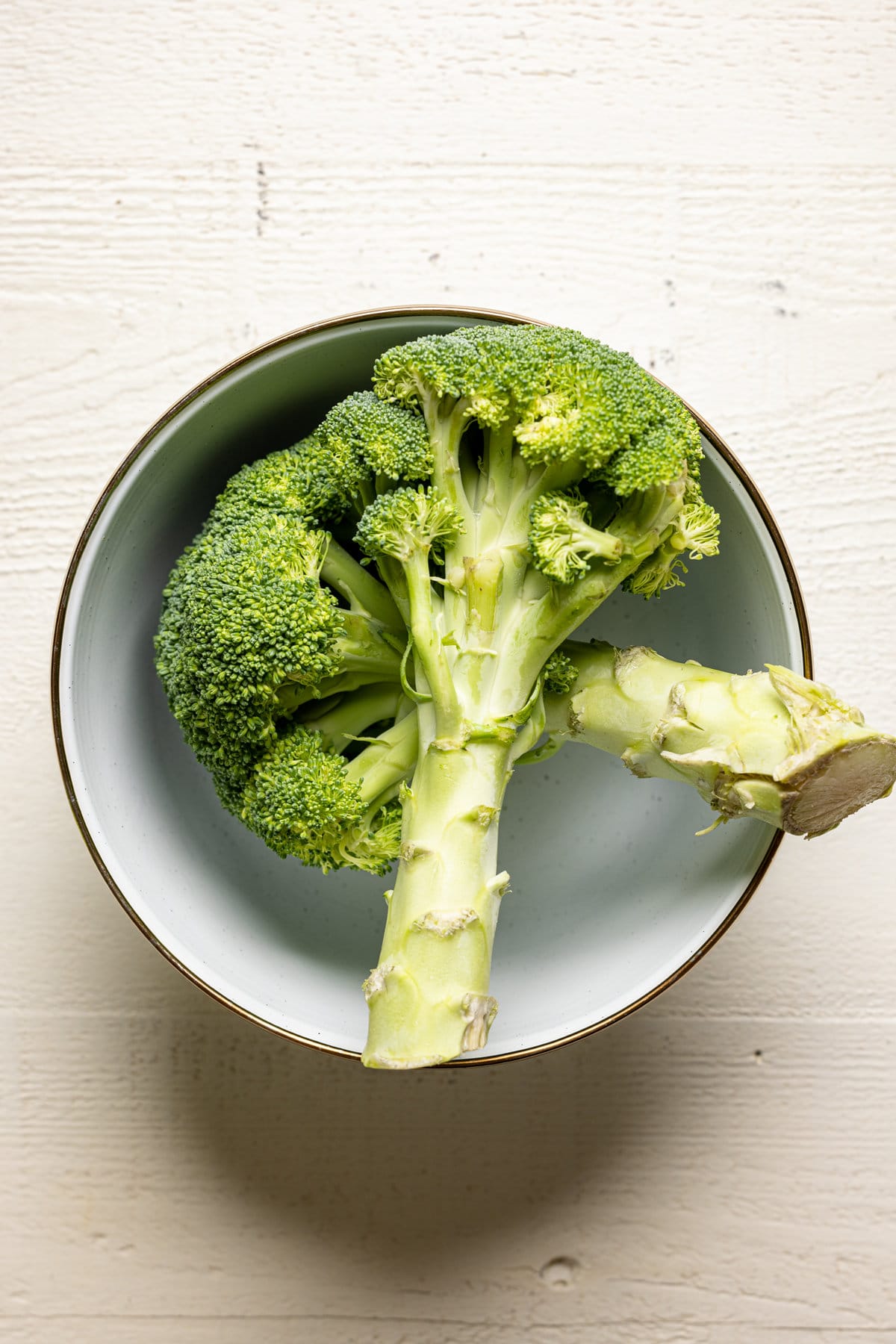 Two broccoli crowns in a bowl