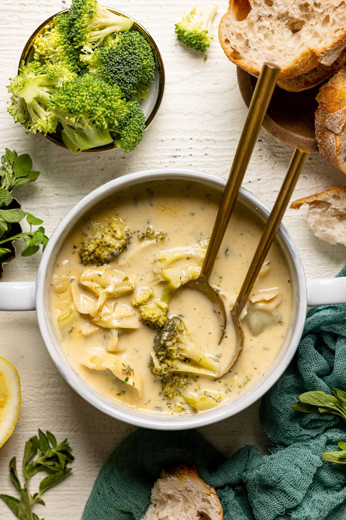 Overhead shot of a bowl of Creamy Lemon Broccoli Tortellini Soup with two spoons