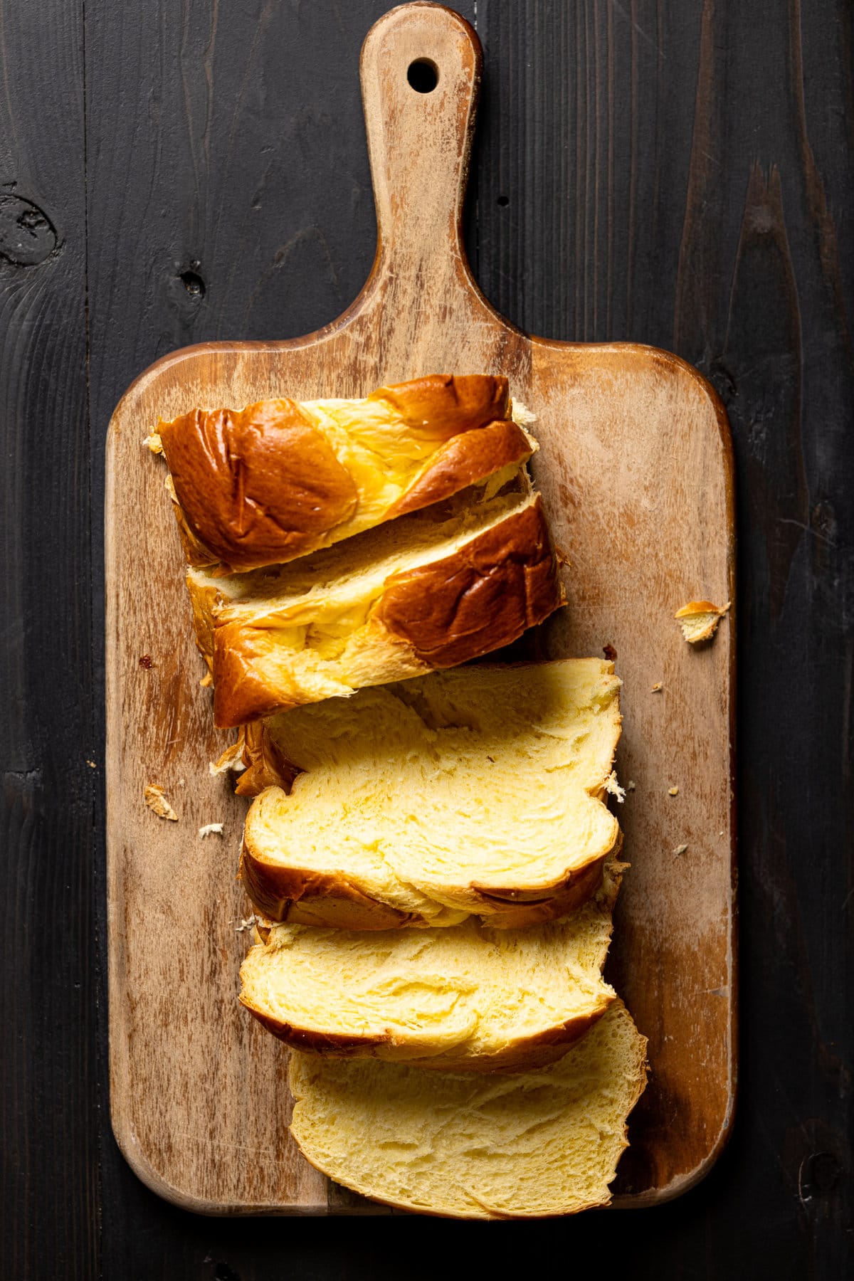 Sliced brioche bread on a wooden cutting board