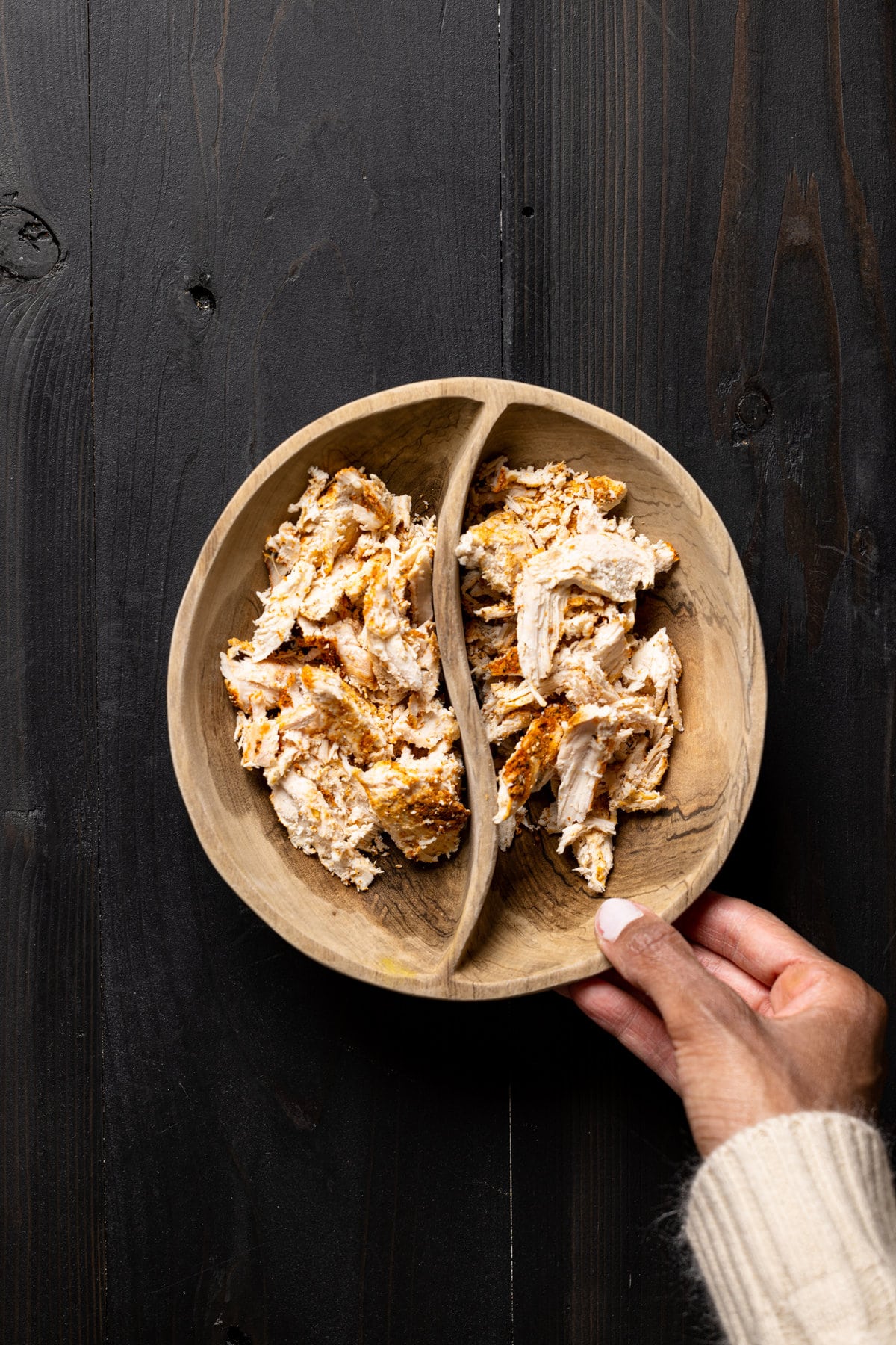 Shredded chicken in a separated wooden bowl
