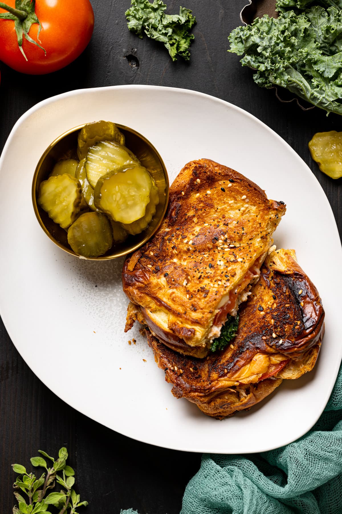 Everything Chicken Tomato Grilled Cheese on a plate with sliced pickles