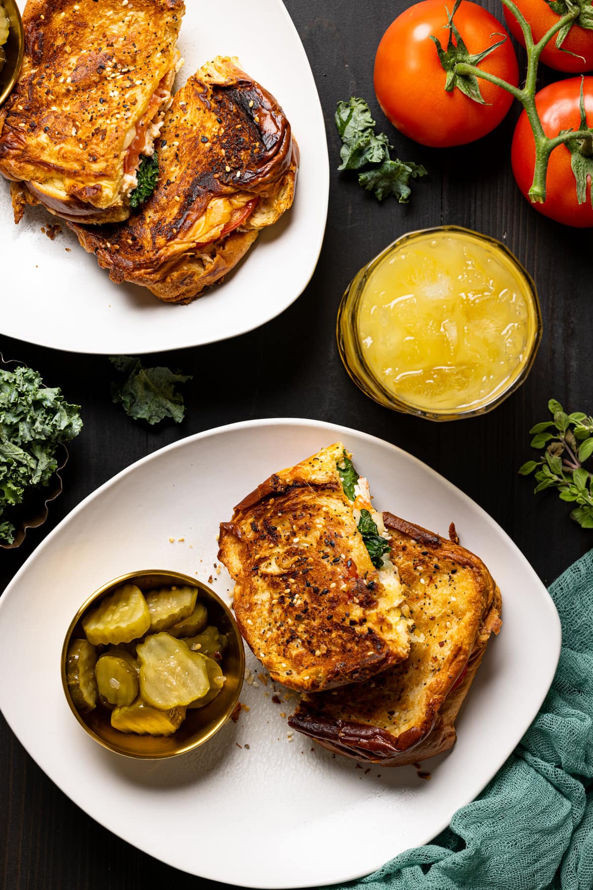 Overhead shot of two Everything Chicken Tomato Grilled Cheeses on plates