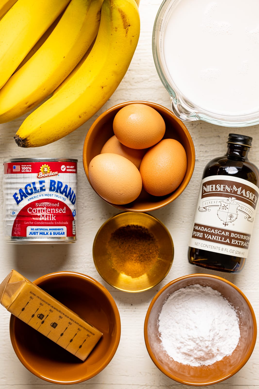 Ingredients for Grandma\'s Baked Southern Banana Pudding, including condensed sweetened milk, bananas, vanilla extract, eggs, butter, milk, and cornstarch. 