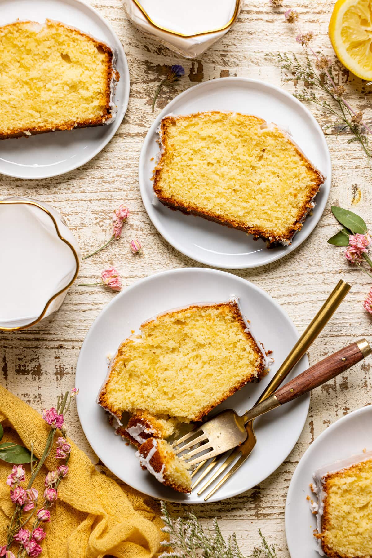 Overhead shot of slices of Iced Lemon Loaf Pound Cake on plates with forks