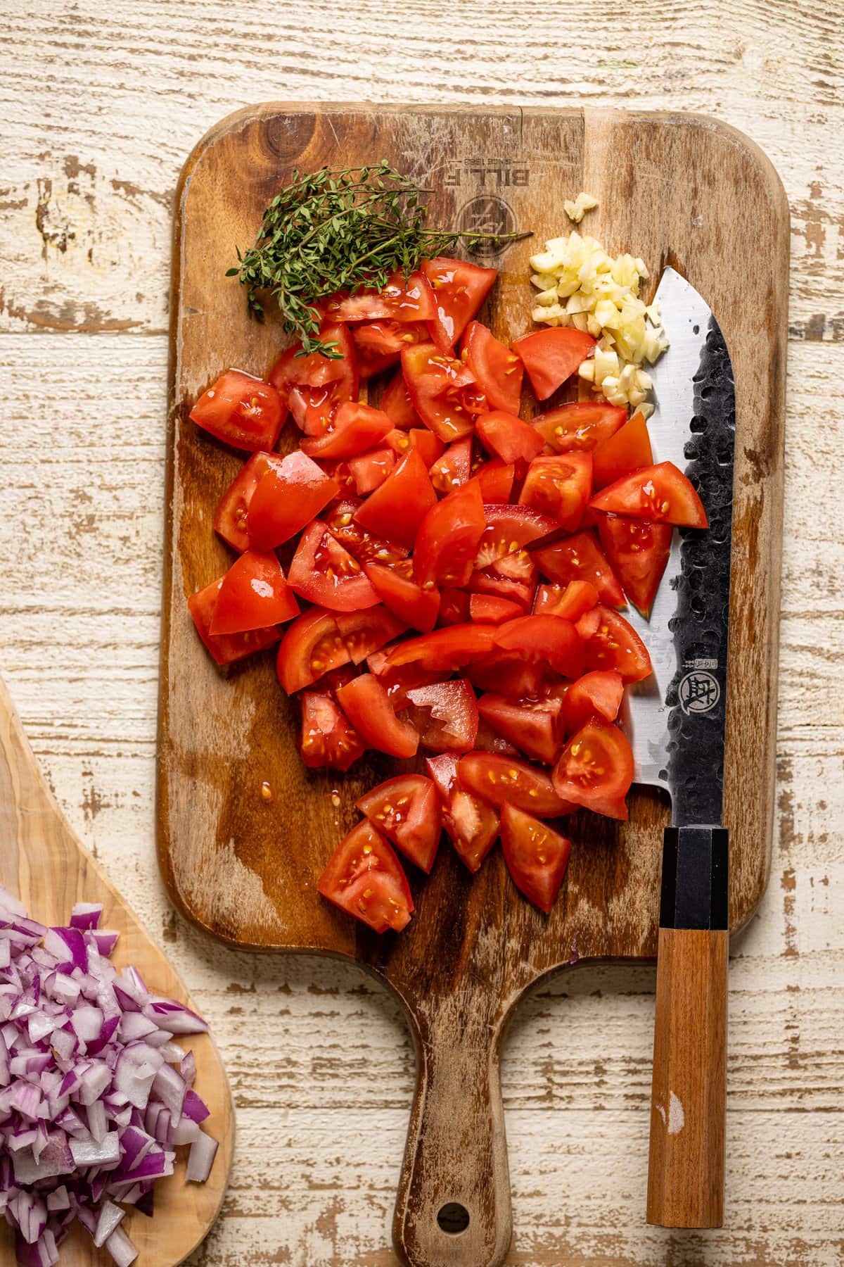 Chopped tomatoes on a cutting board with a knife