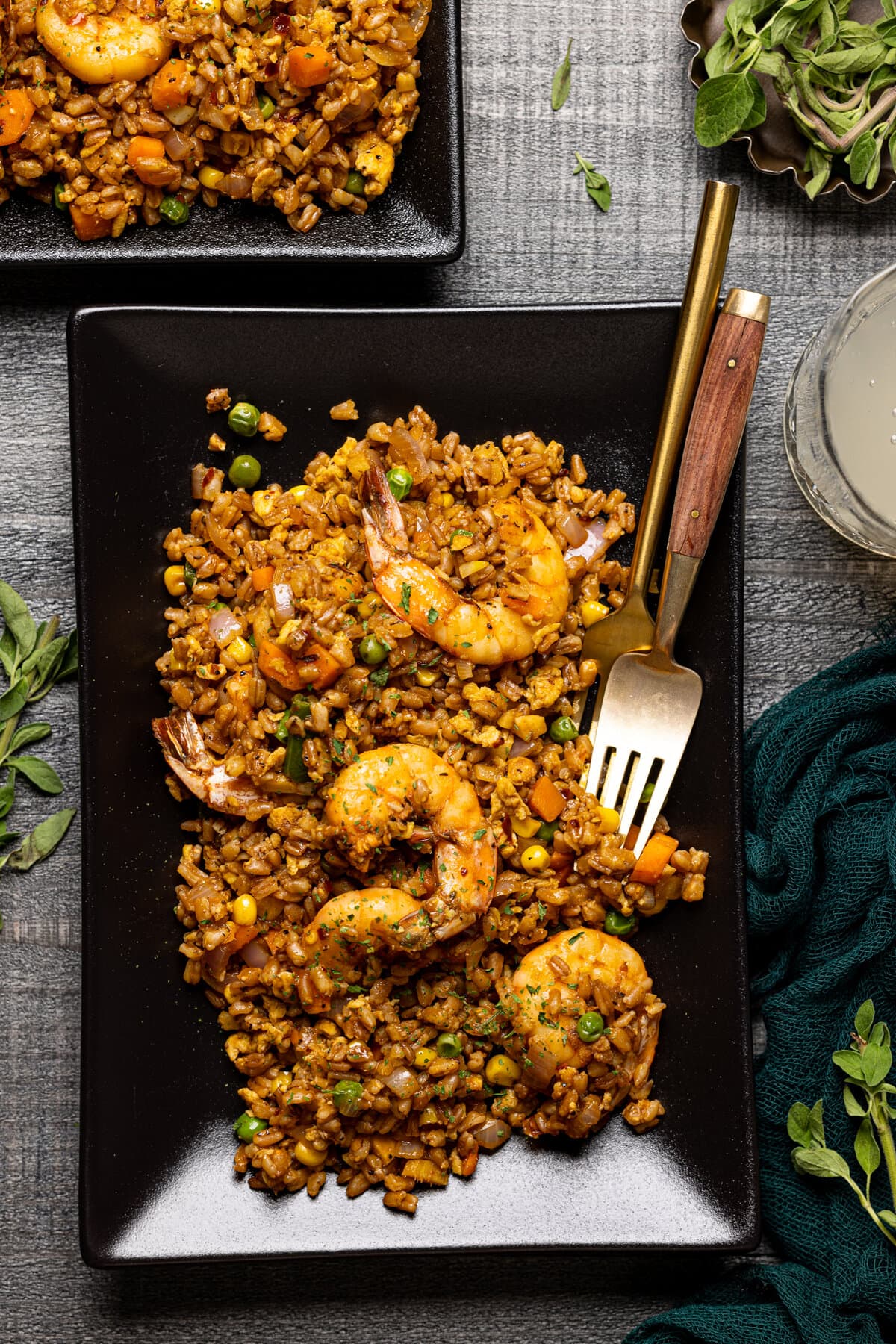 Closeup of Healthy Weeknight Shrimp Fried Rice on a black, rectangular plate with a fork