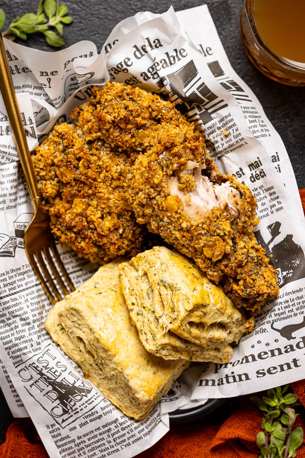 Fried chicken in a food basket with biscuits, a fork, with a red napkin and a drink.