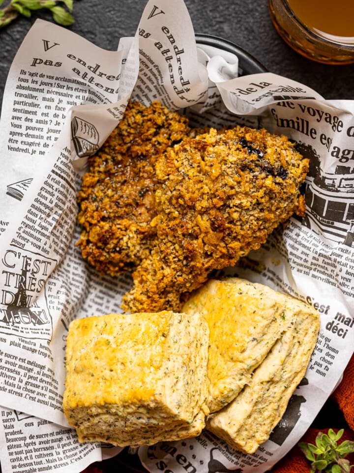 A food basket with chicken and biscuits.