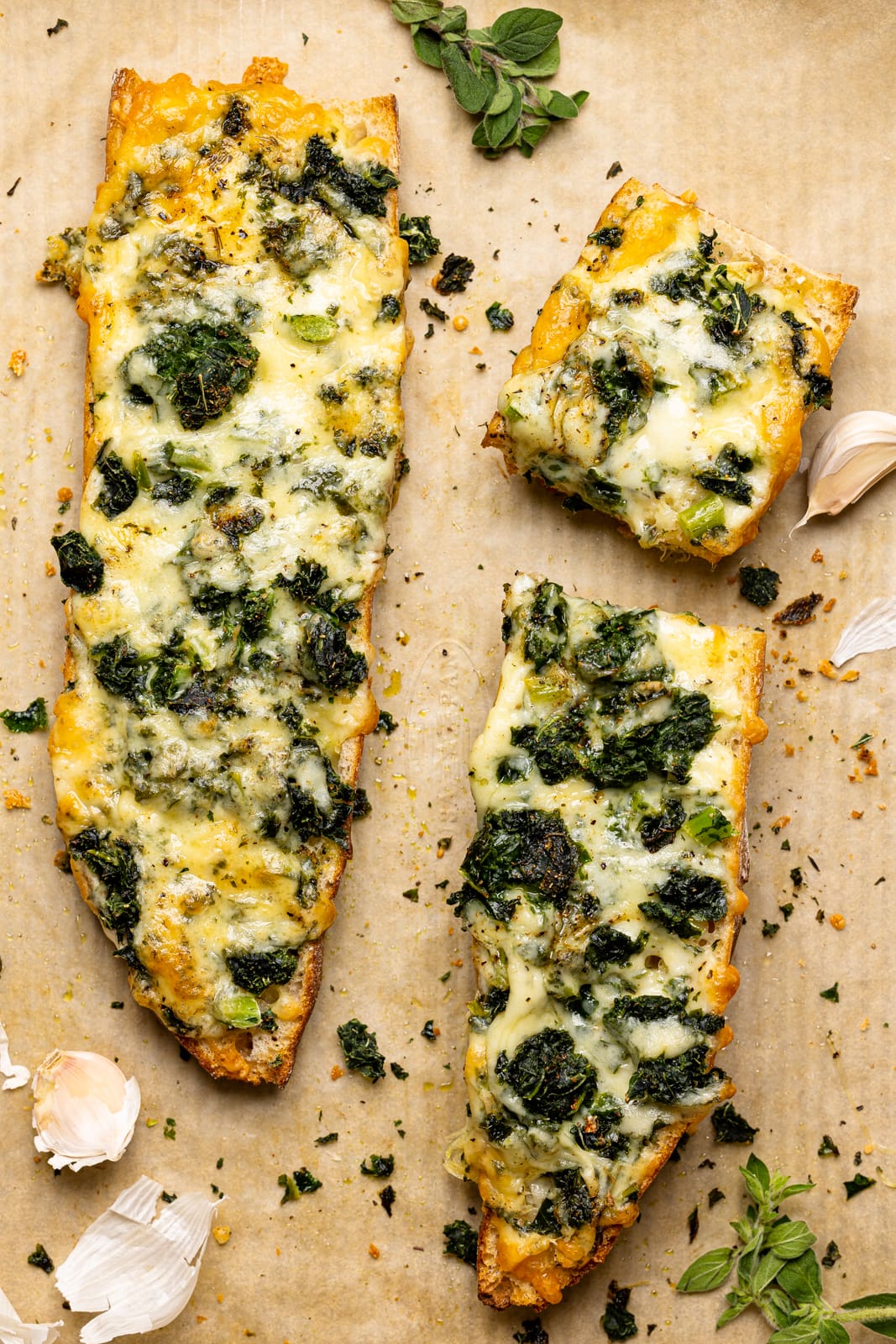 Baked French bread with garlic and herbs on a baking sheet with parchment paper.