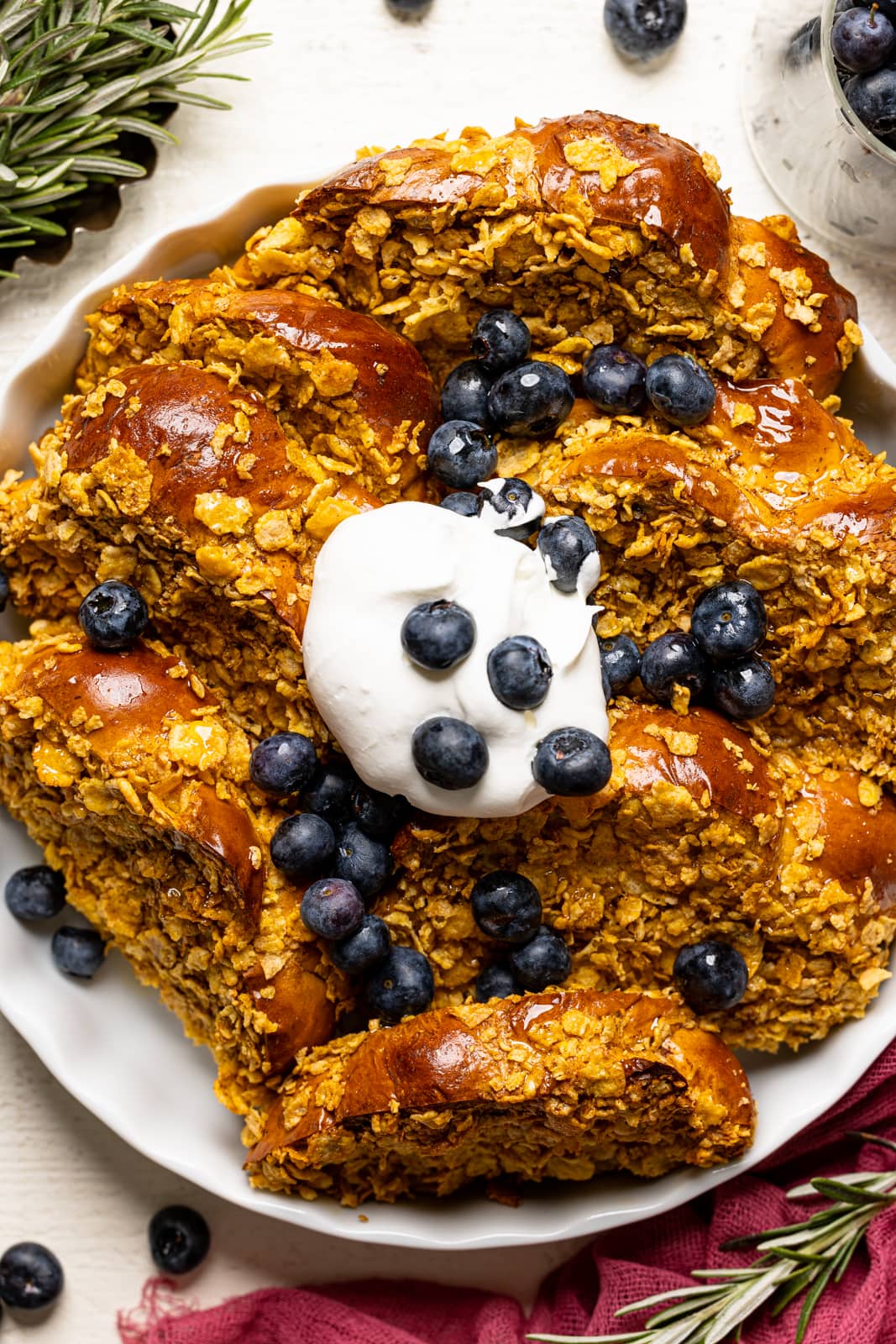 Up close shot of baked french toast in a white baking dish with blueberries.