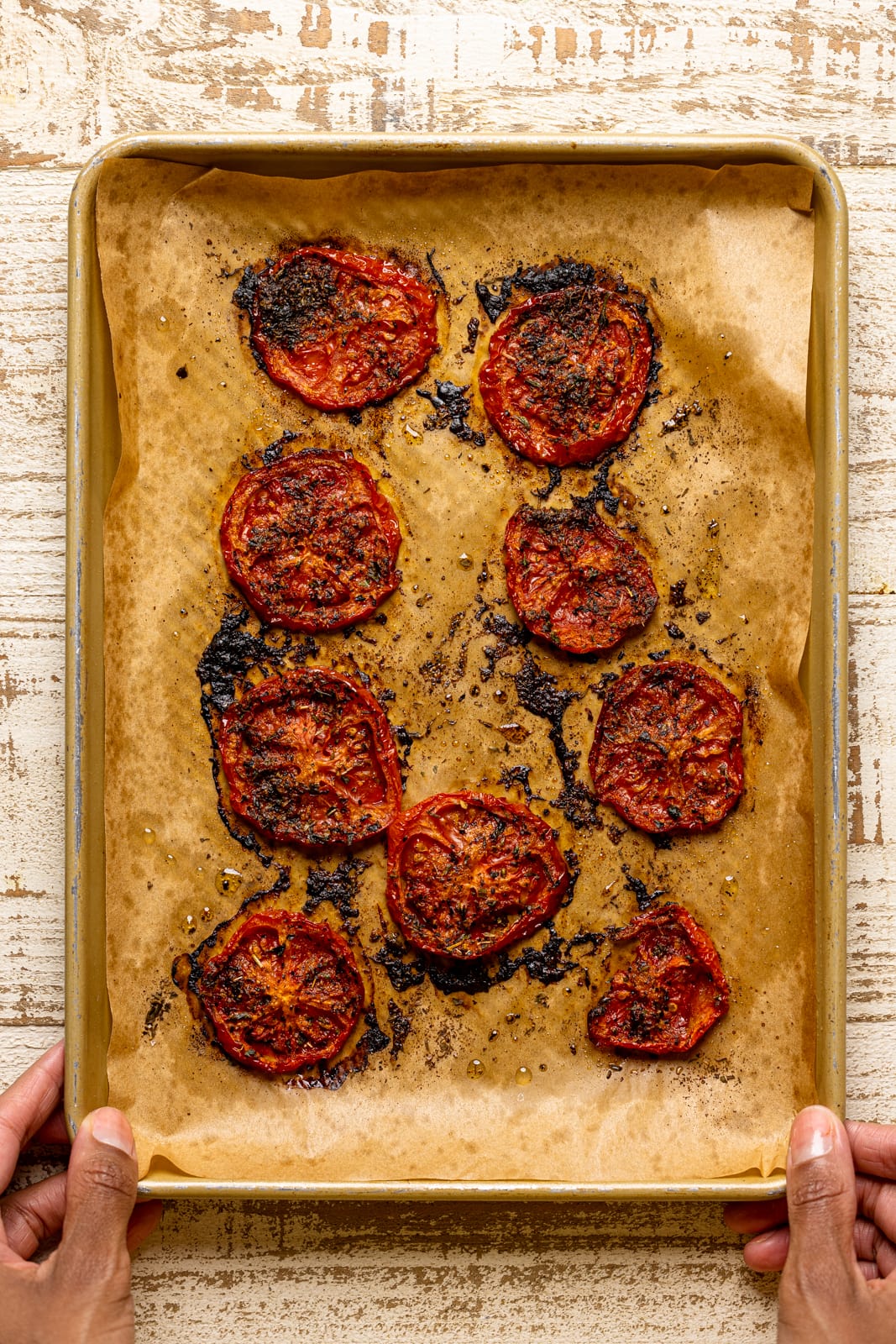 Roasted tomatoes on a baking sheet with parchment paper. 