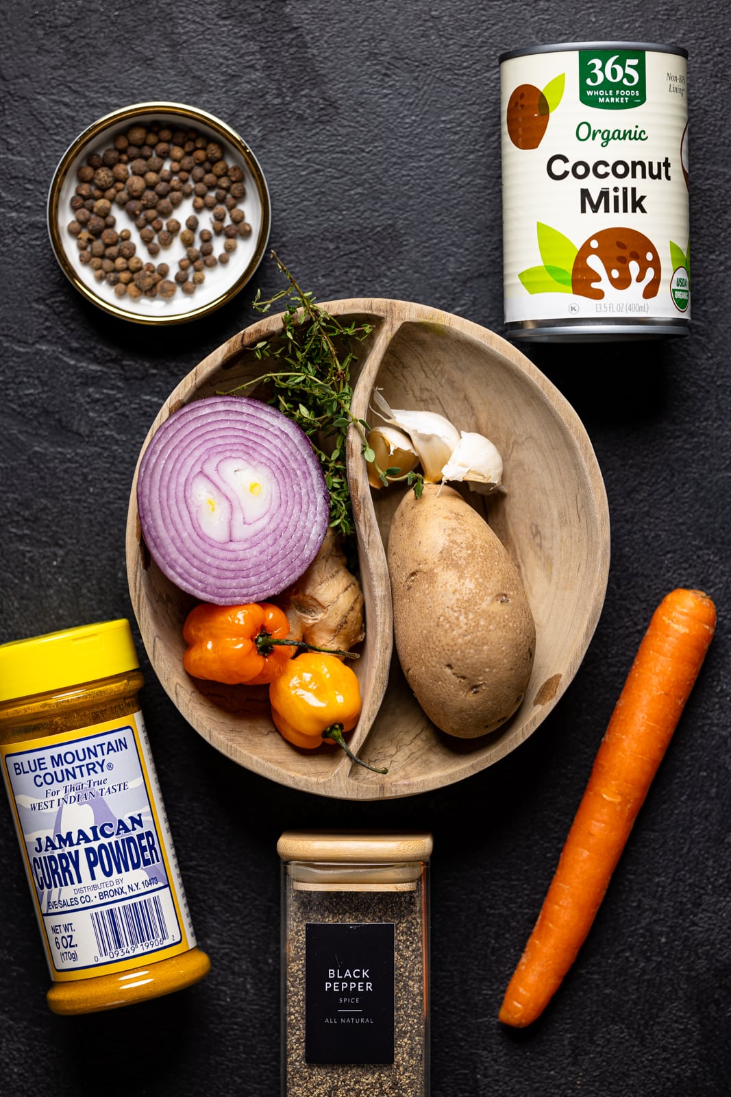 Ingredients including carrot, coconut milk, curry powder, veggies, and herbs + seasonings. 