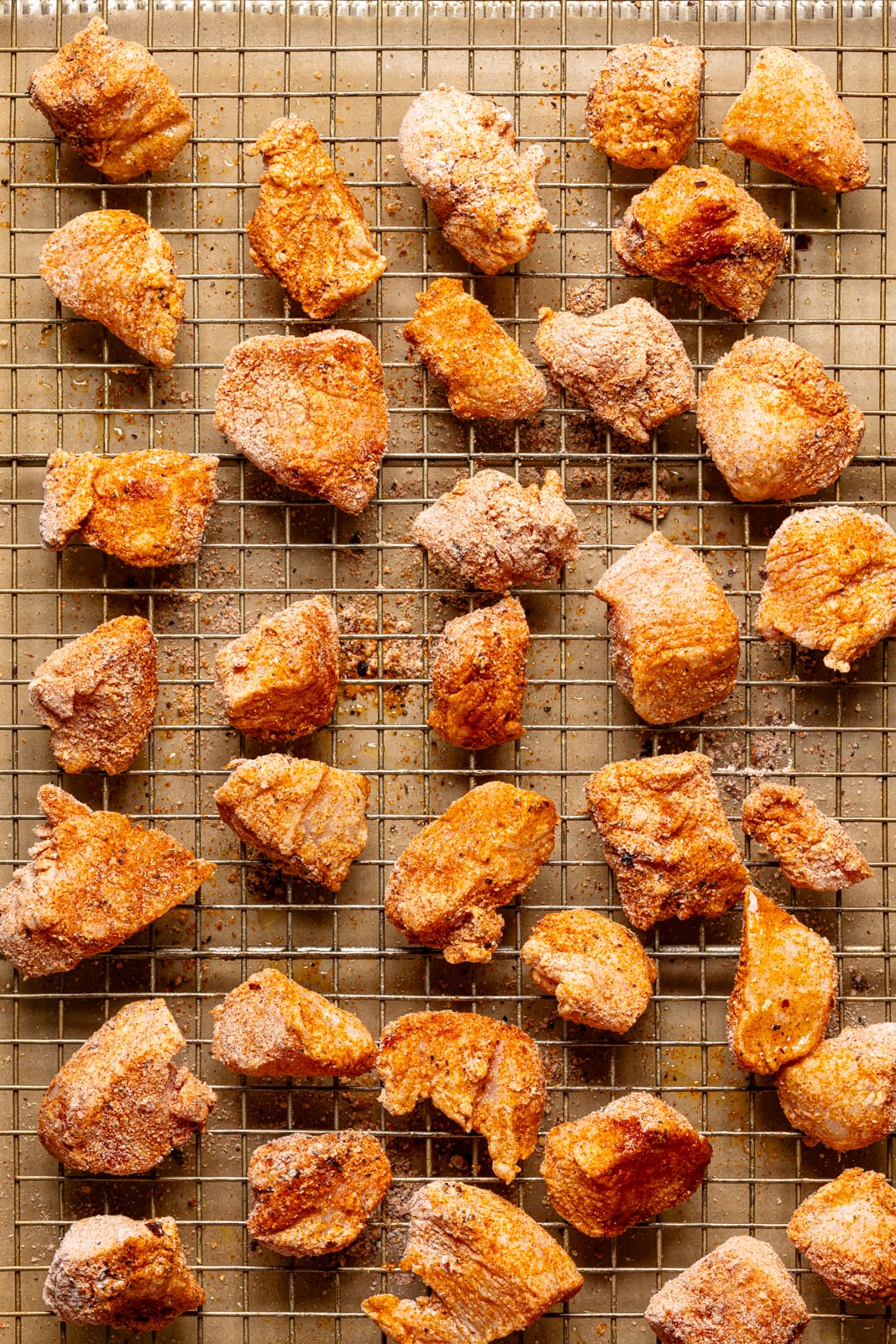 Seasoned chicken on a baking sheet with a wire rack. Healthy chicken recipe for a weeknight dinner.