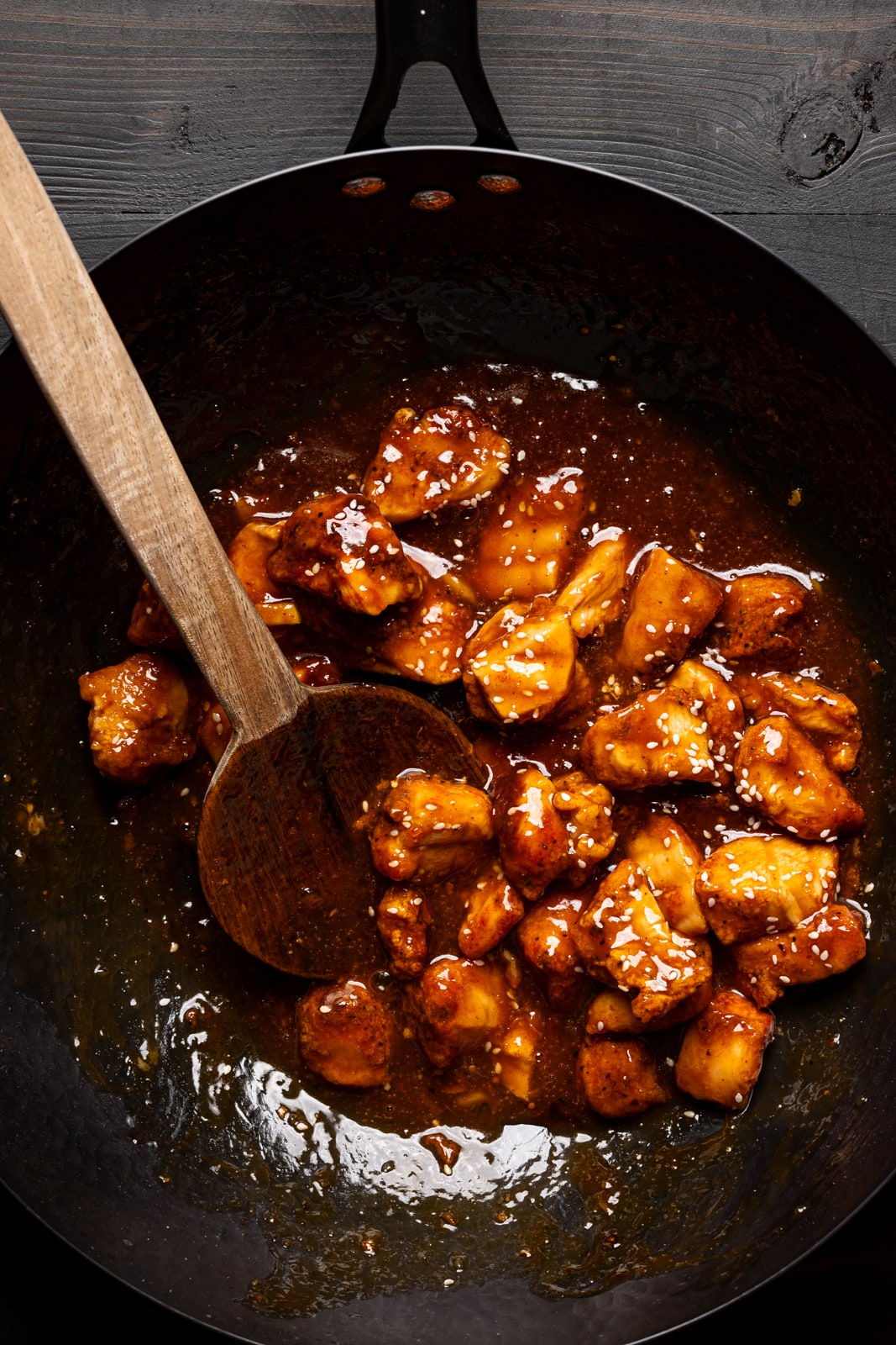 Cooked chicken in a black skillet with a wooden spoon. Getting ready for the perfect weeknight dinner.