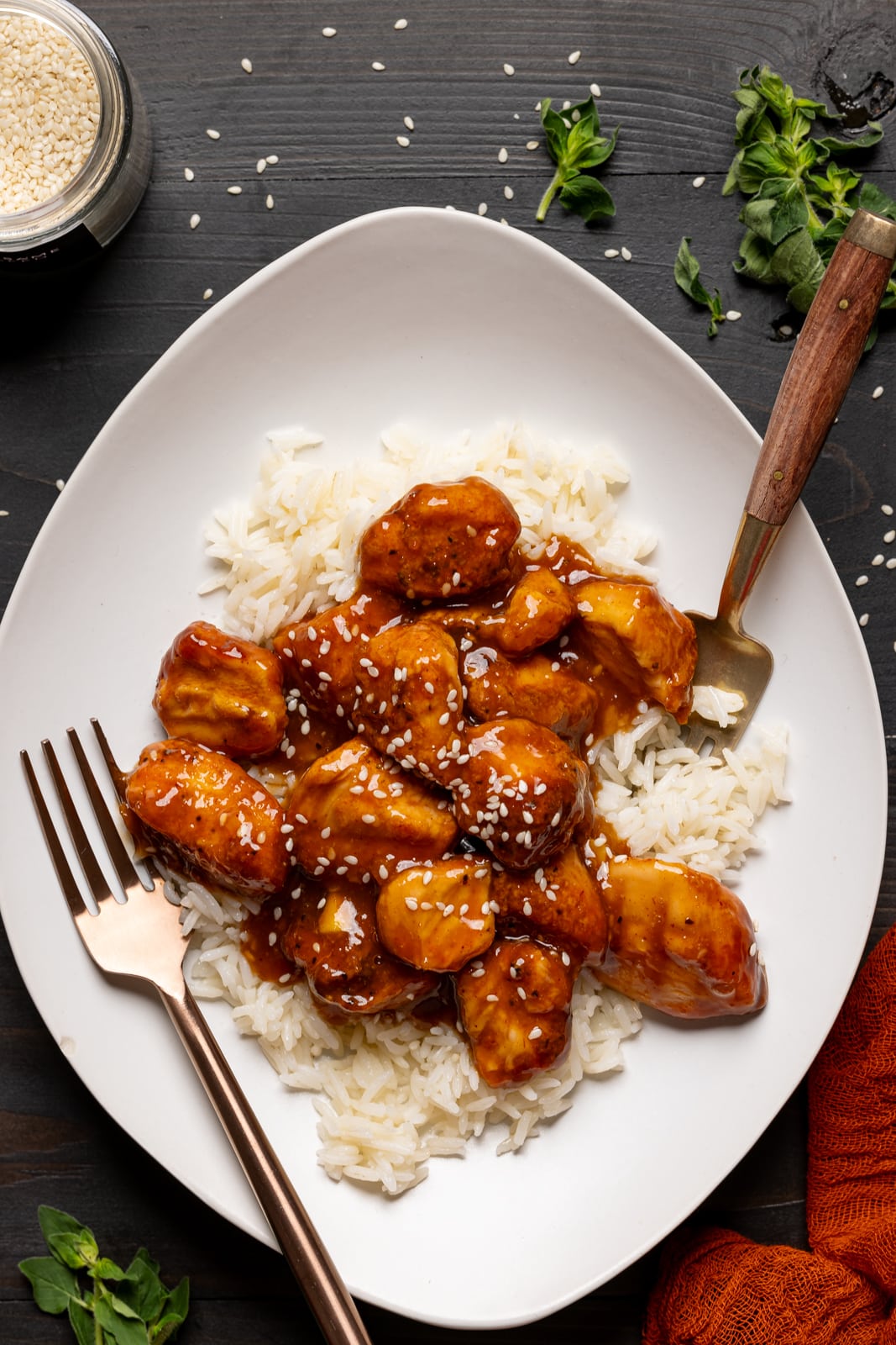 Chicken and rice in a plate with two forks on a black table. The perfect weeknight dinner.