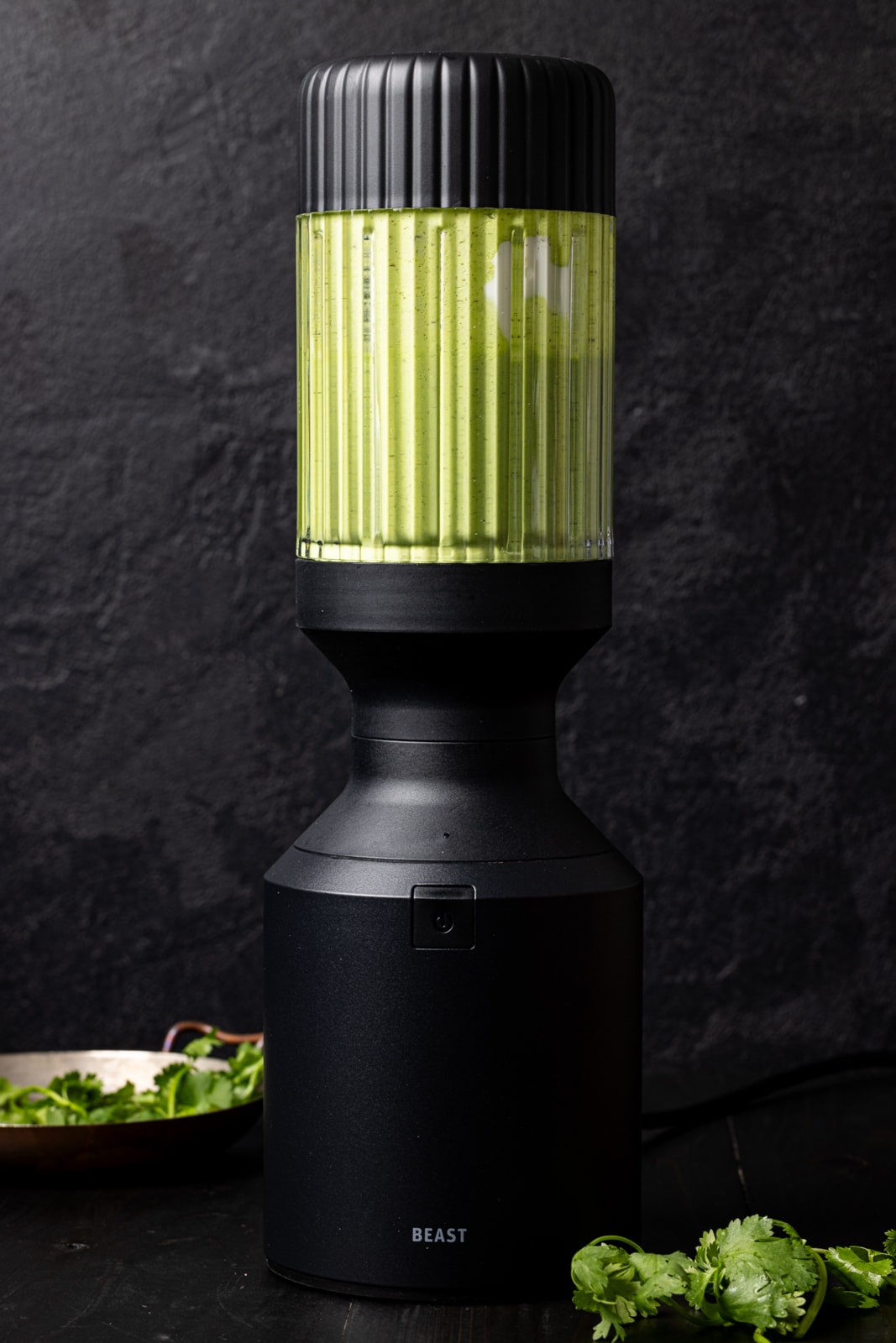 Green goddess dressing in a black blender. 