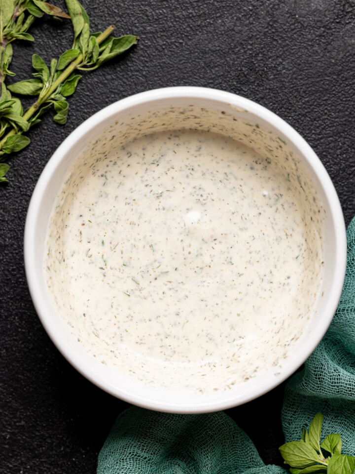 Homemade dressing in a white bowl on a black table.