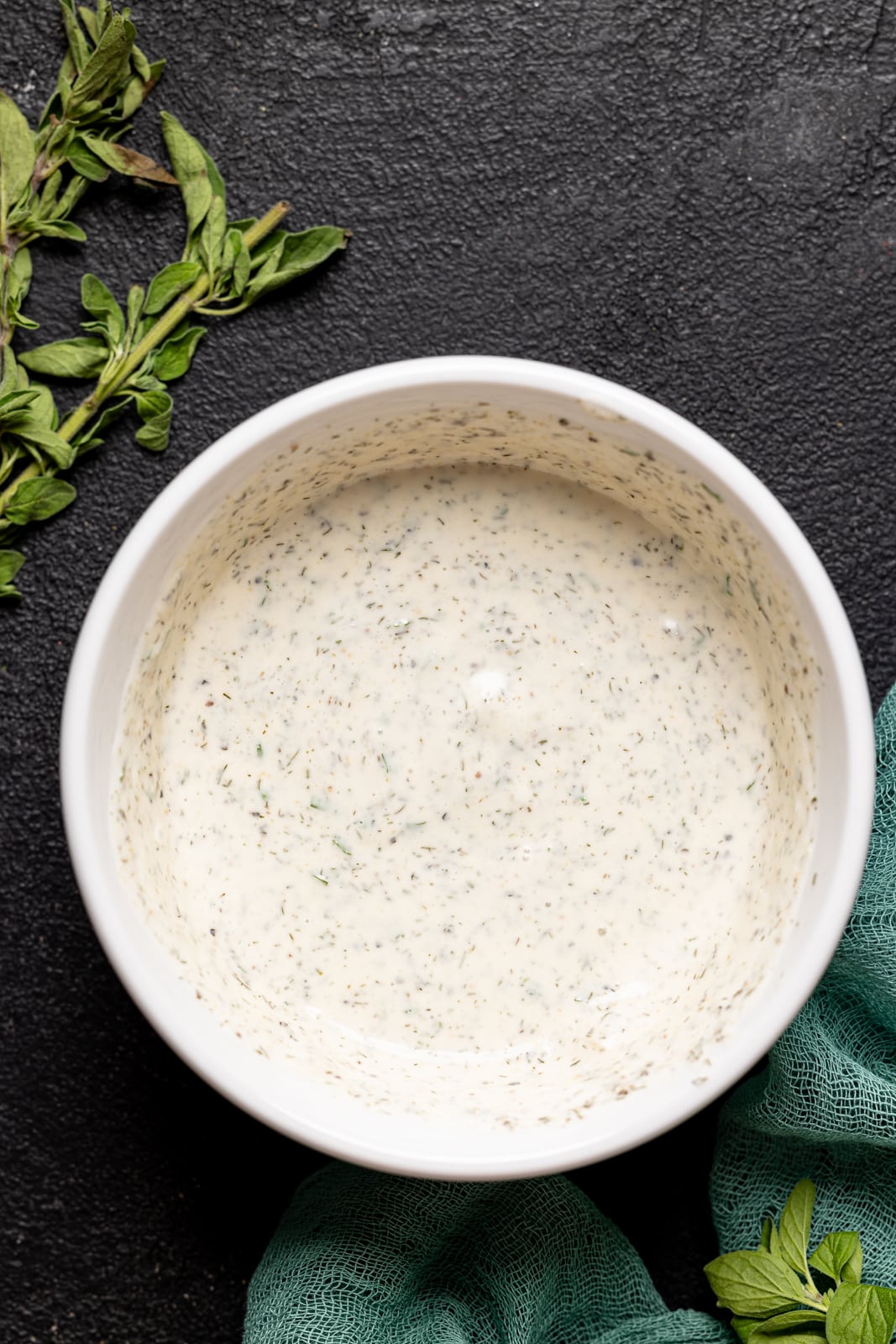 Homemade dressing in a white bowl on a black table. 