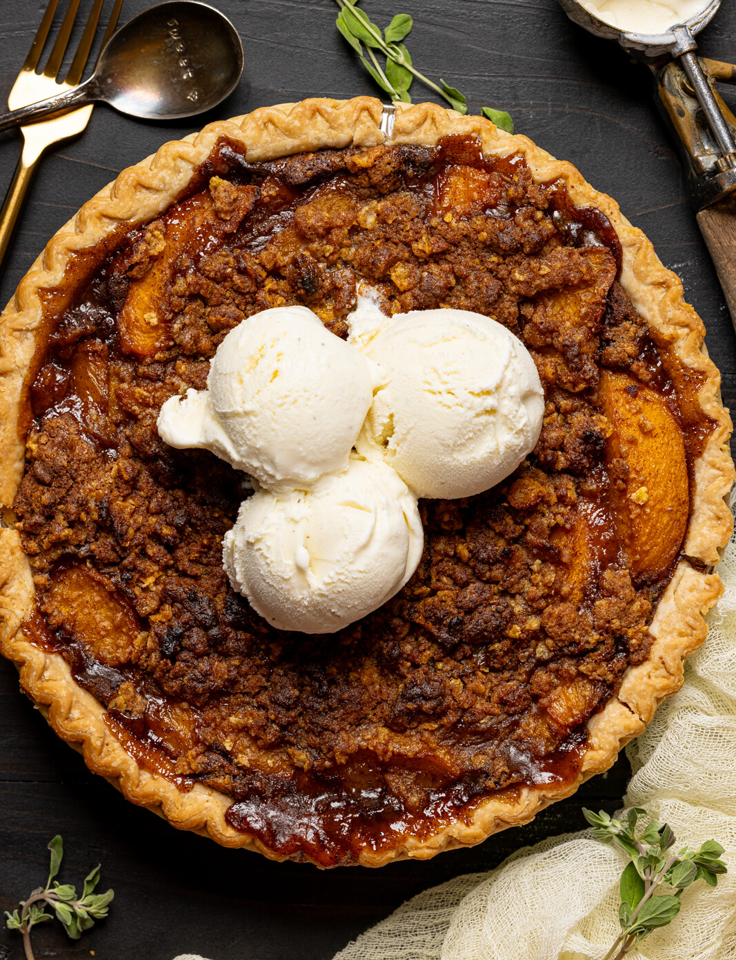 Pie with ice cream scoops and spoons with herbs.