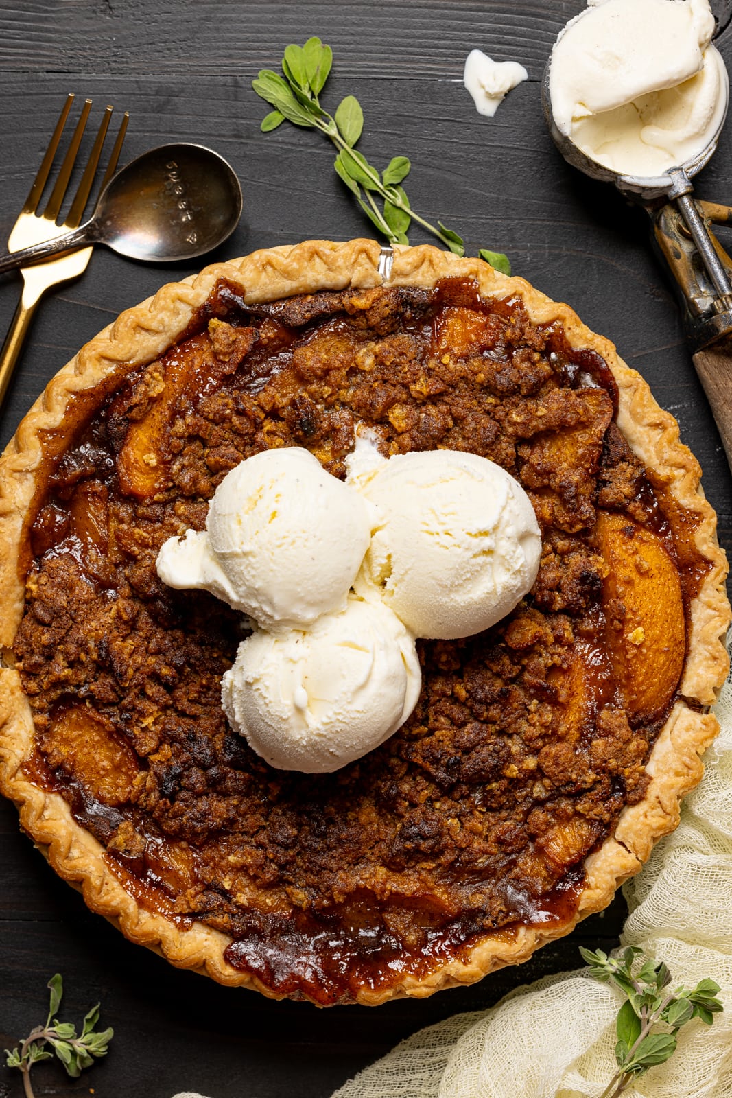 Pie with ice cream scoops and spoons with herbs.