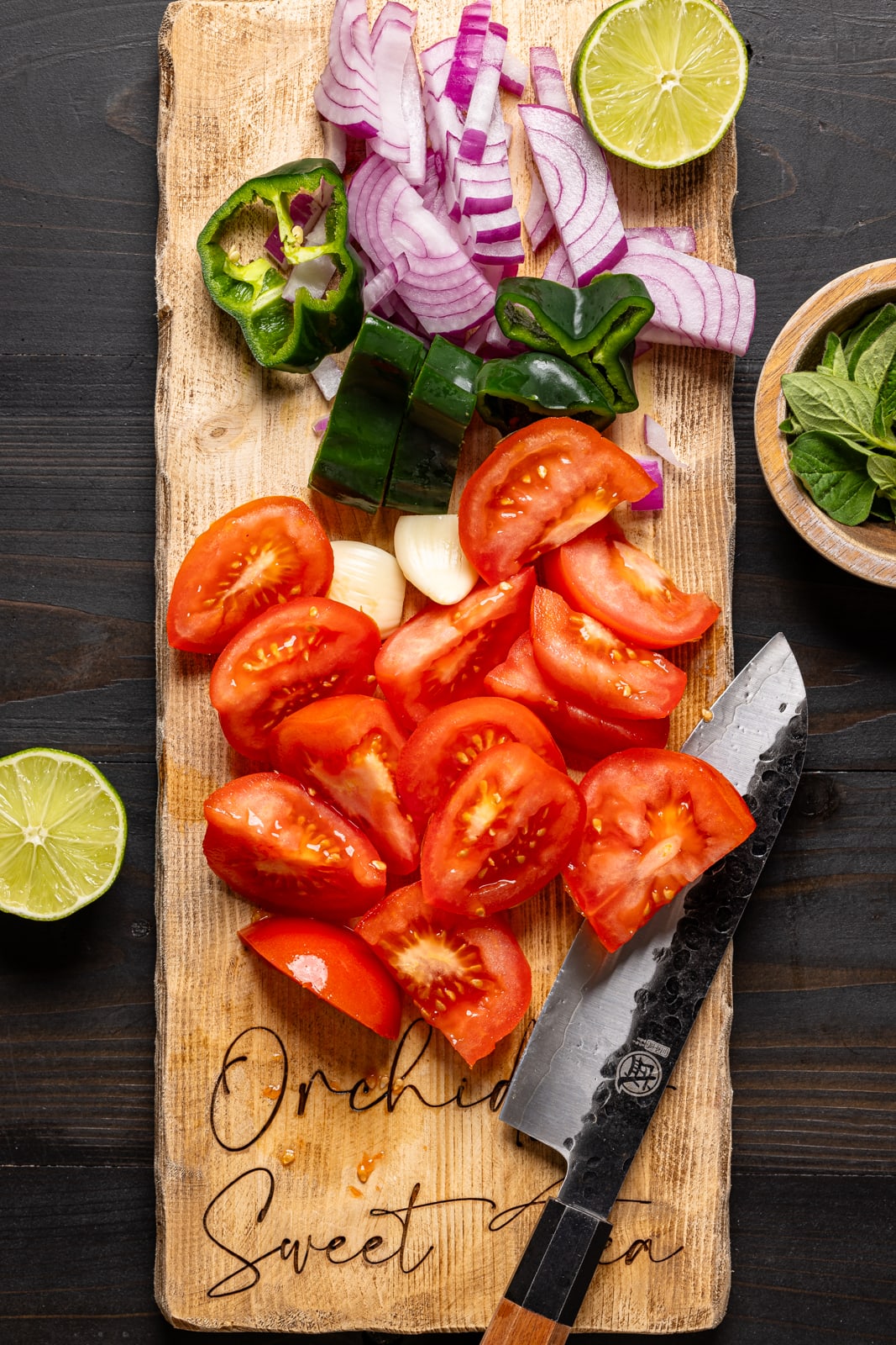 Chopped veggies on a cutting board with a knife. Restaurant style salsa recipe.