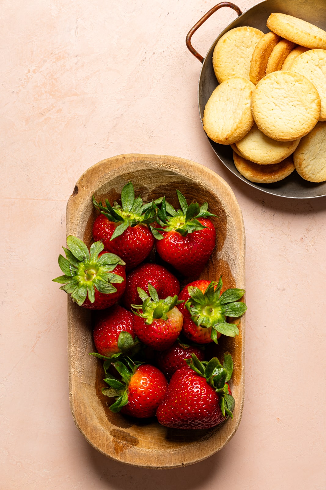 Fresh strawberries in a brown bowl and shortbread cookies.