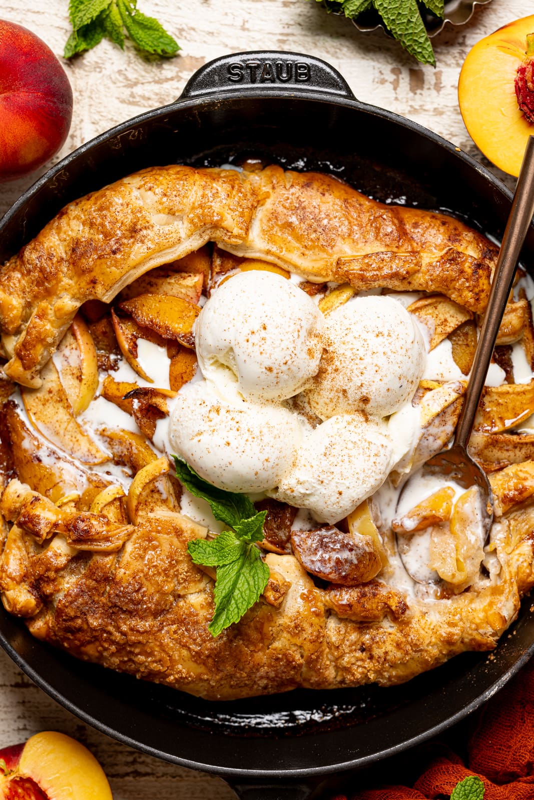 Up close shot of baked crisp with puff pastry and ice cream and spoon.