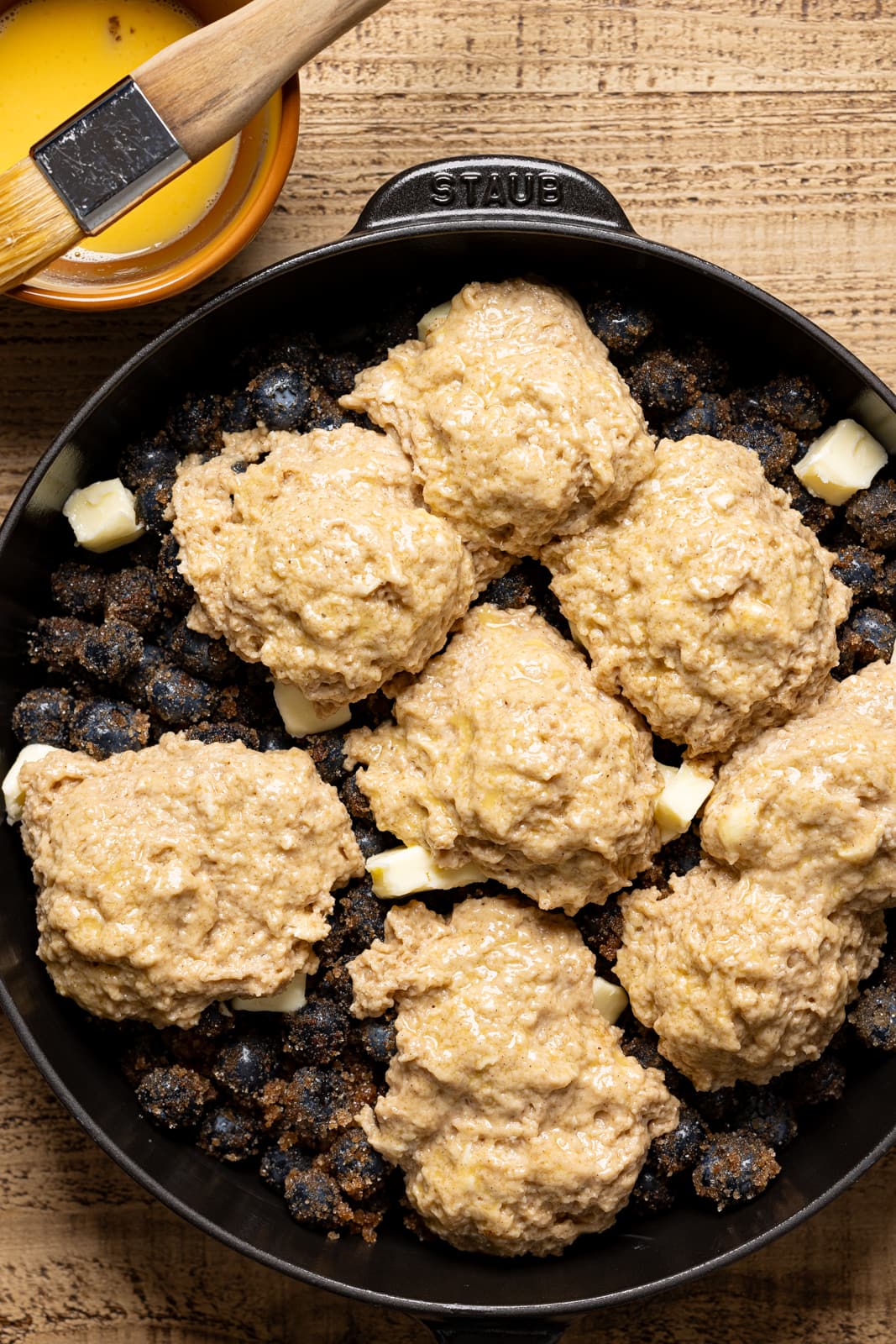 Biscuits atop blueberry filing in a skillet. 