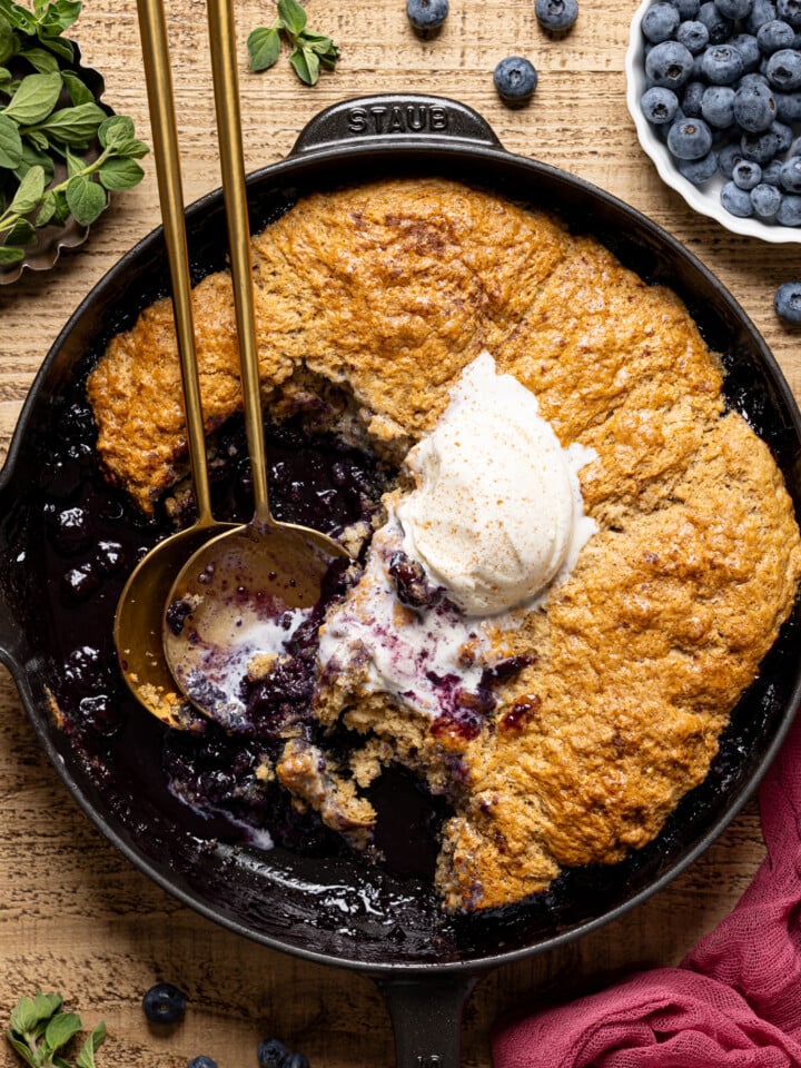Cobbler scooped out with ice cream and two spoons.