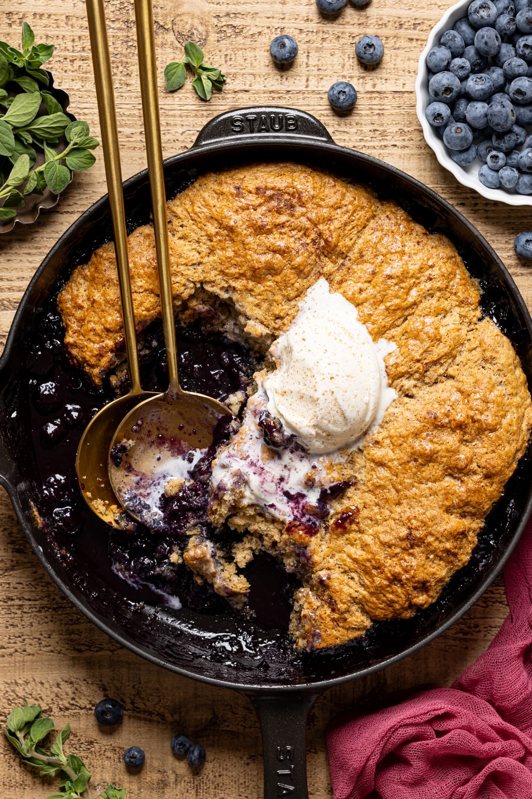 Cobbler scooped out with ice cream and two spoons.